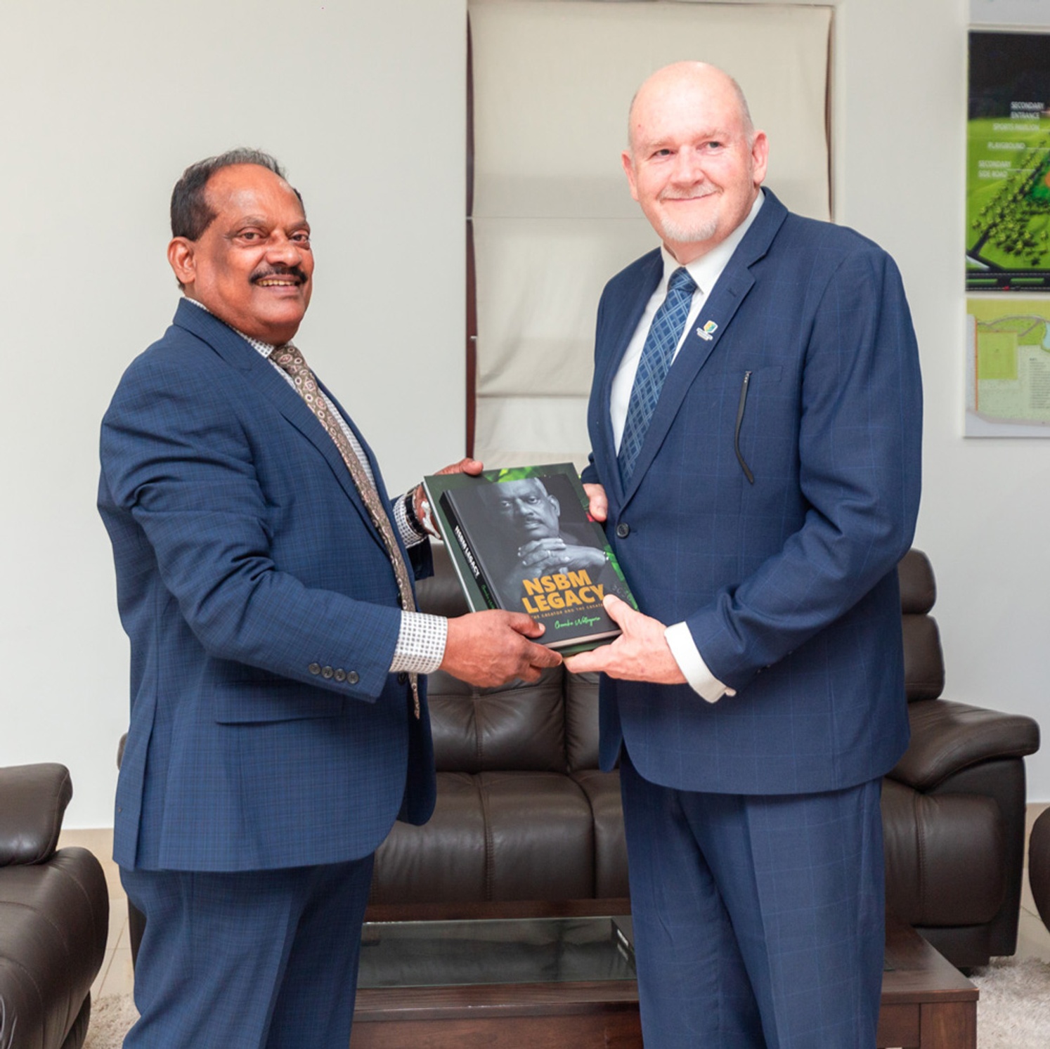 two men in suits holding a book