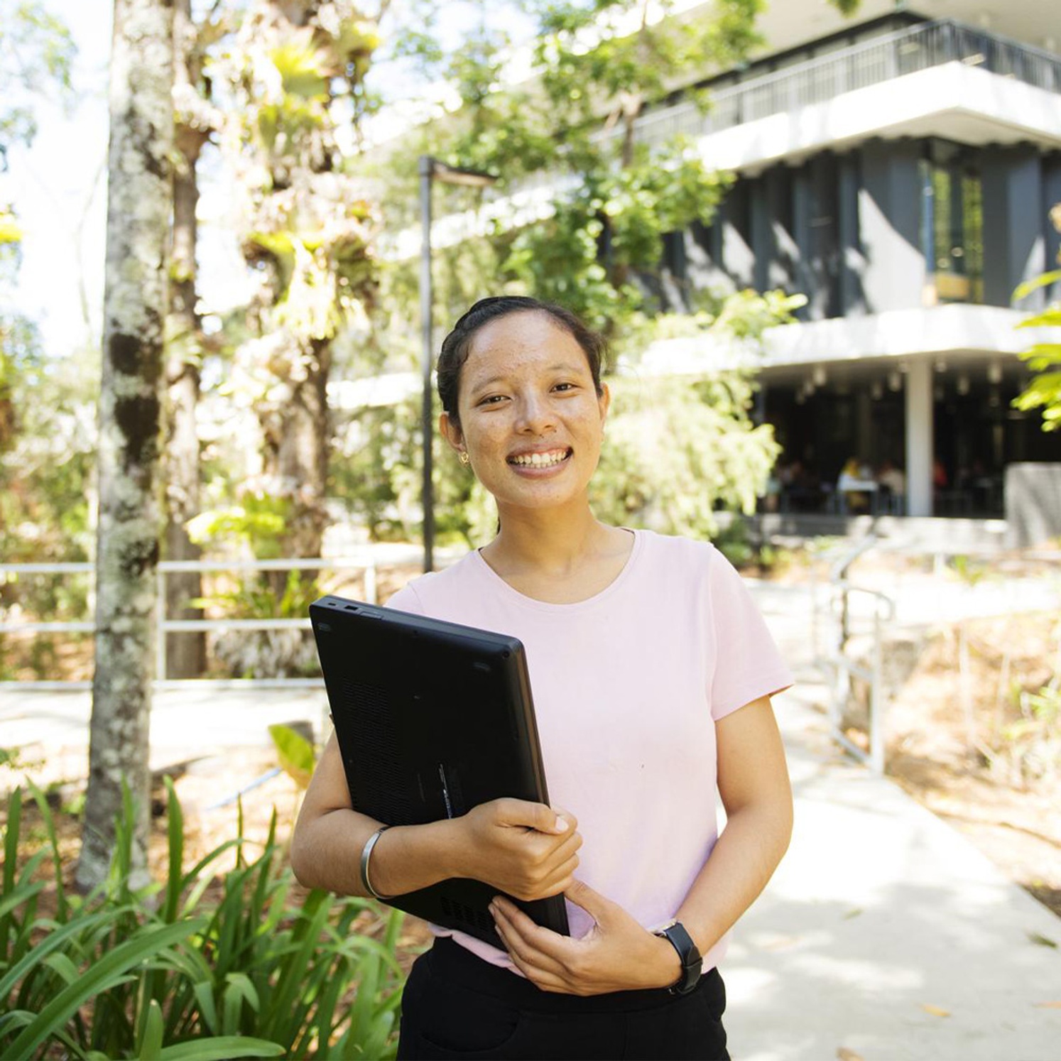 female student of front of building holding books