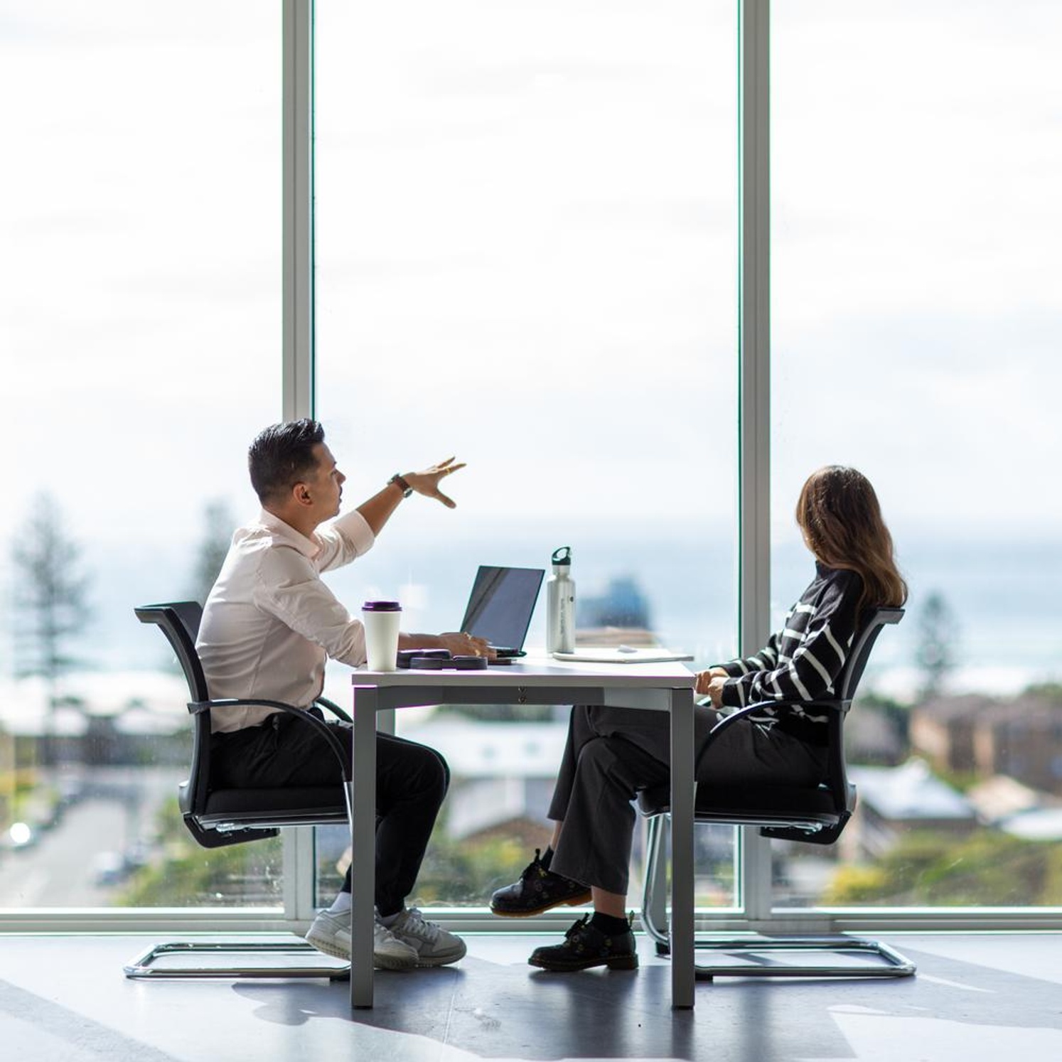 A man and woman chatting with a laptop on the Gold Coast campus