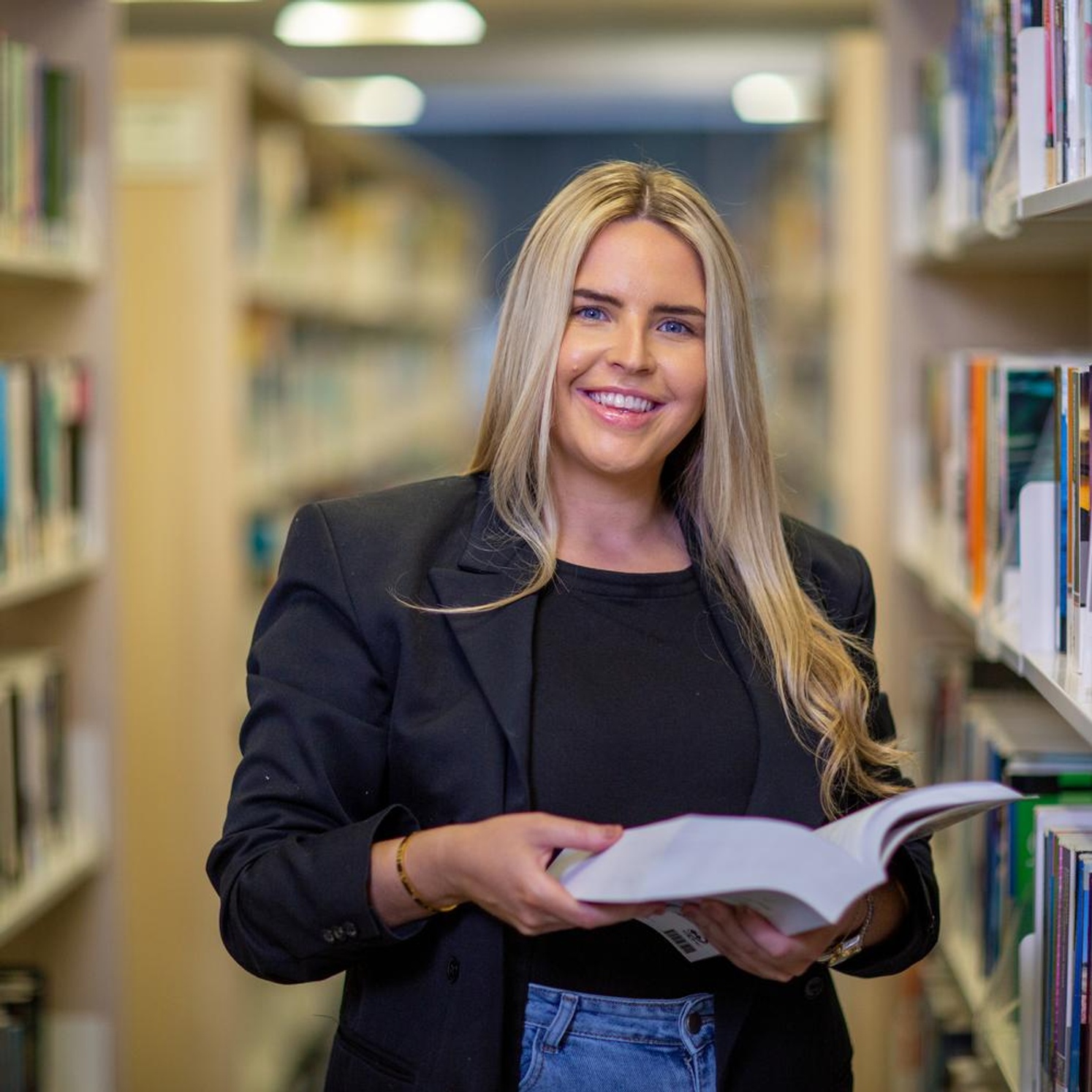student in library with book
