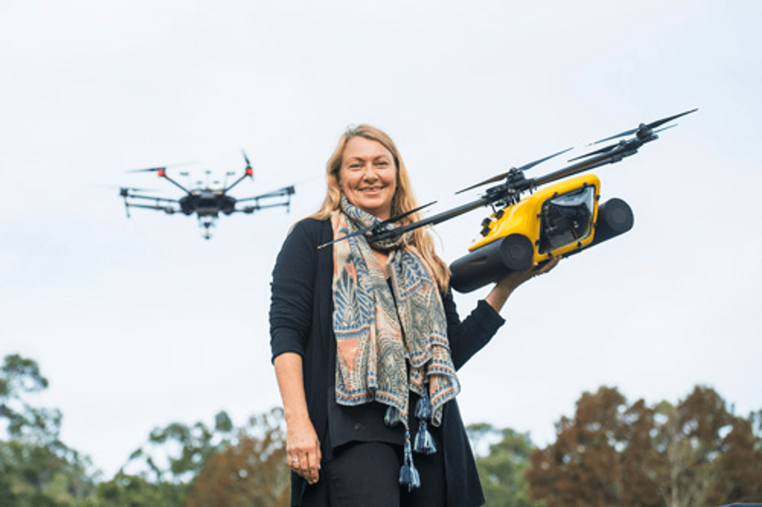 A woman holding a large drone