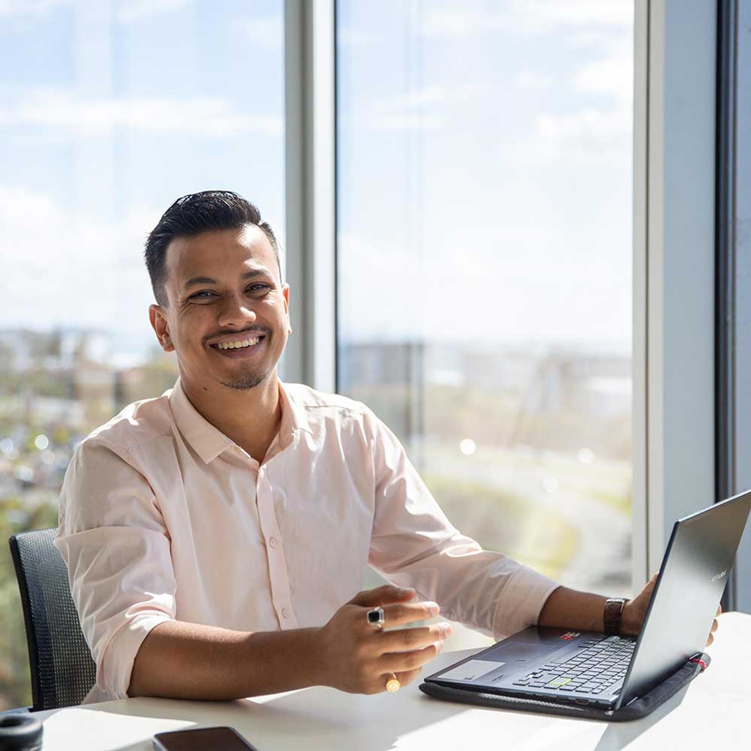 International student smiling with laptop on the Gold Coast campus