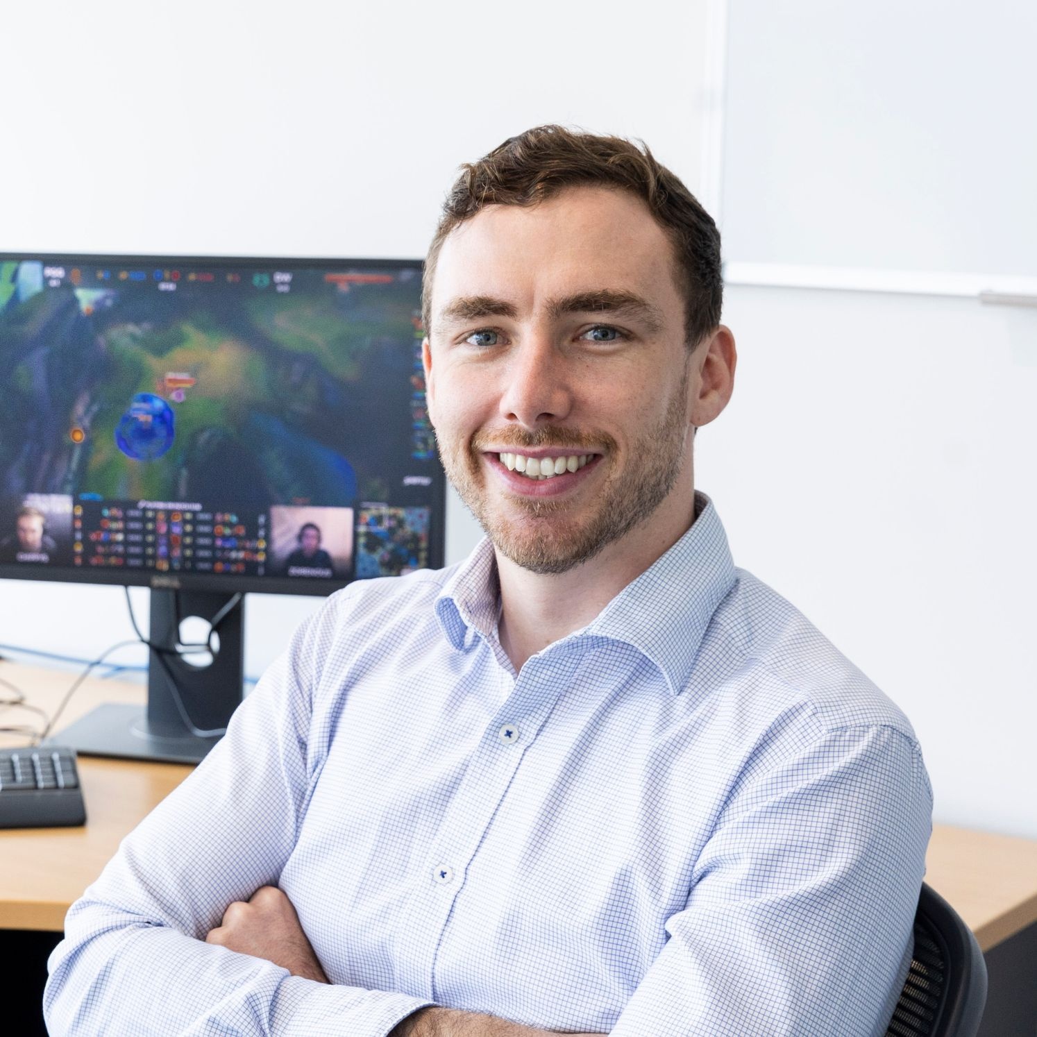 Portrait of Dr Dylan Poulus in front of computer
