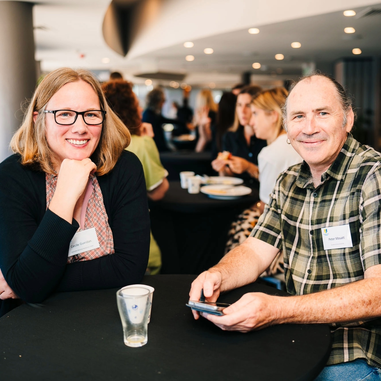 Two professionals posing for a photo at a conference