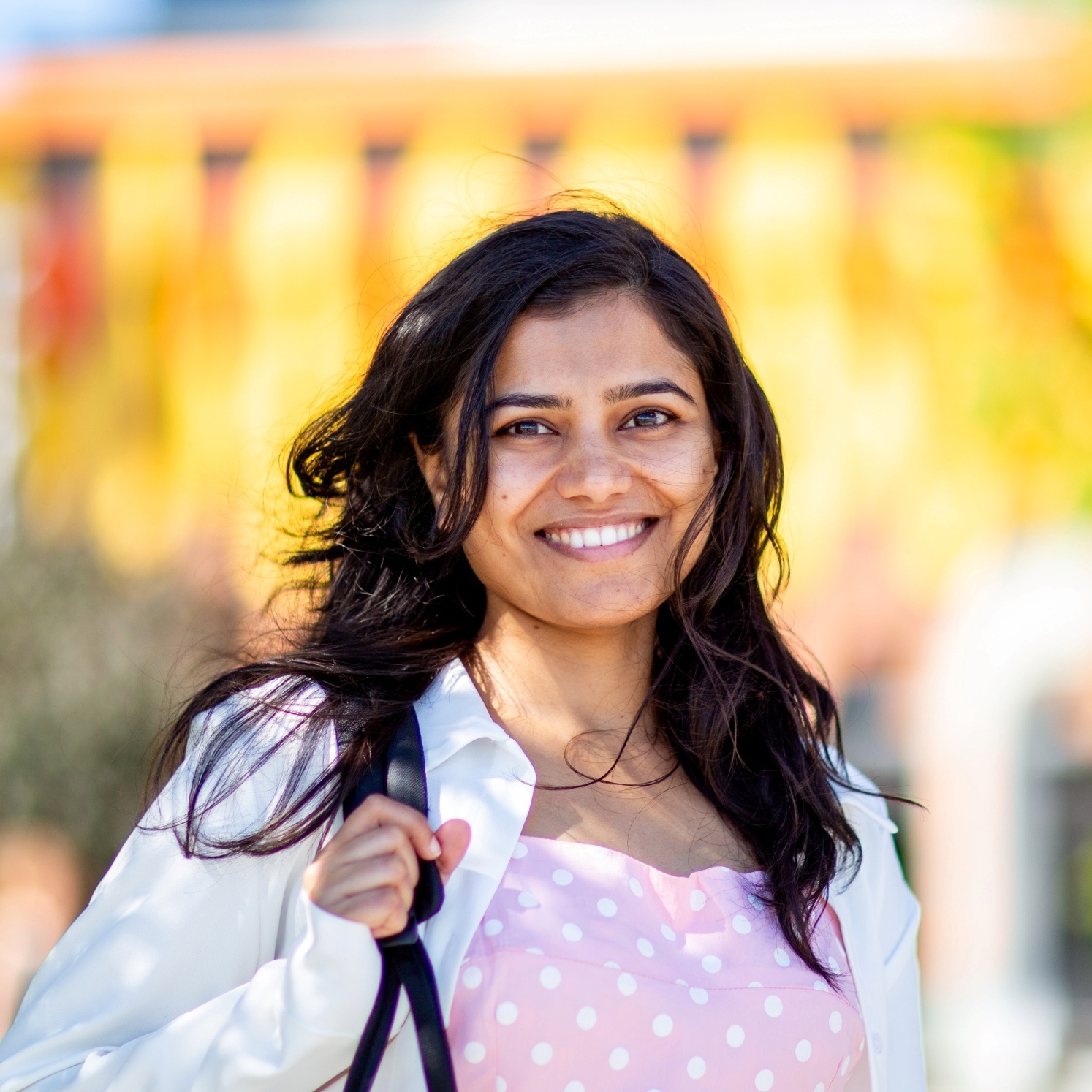 Student smiling in front of building