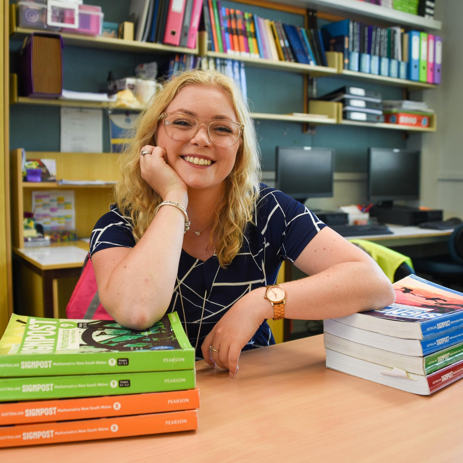 Student smiling with stack of books