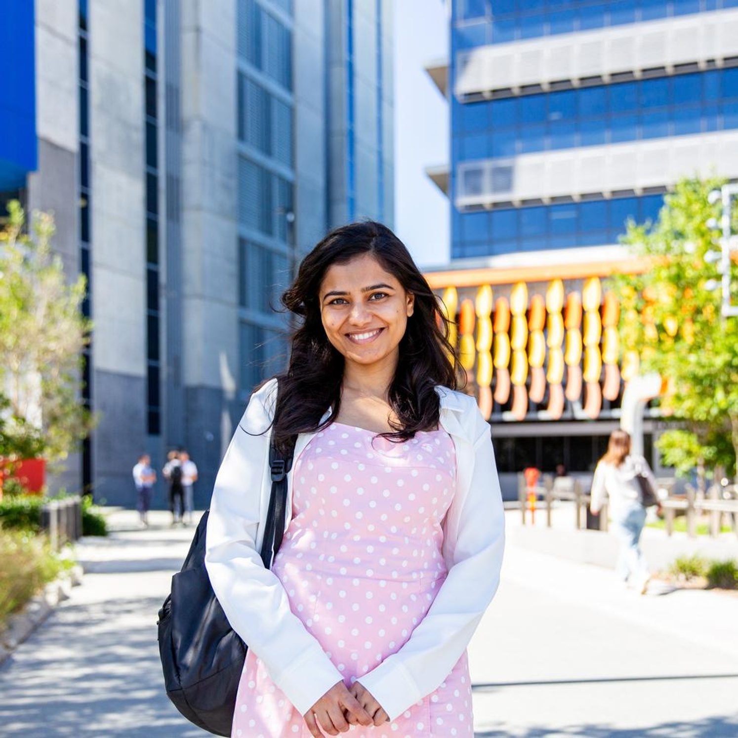 Student smiling on the Gold Coast campus wearing backpack