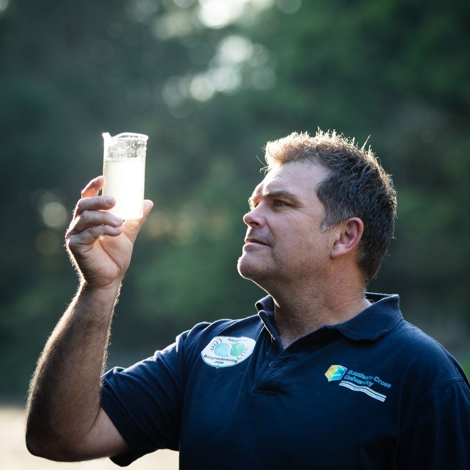 Man assessing beaker of river water