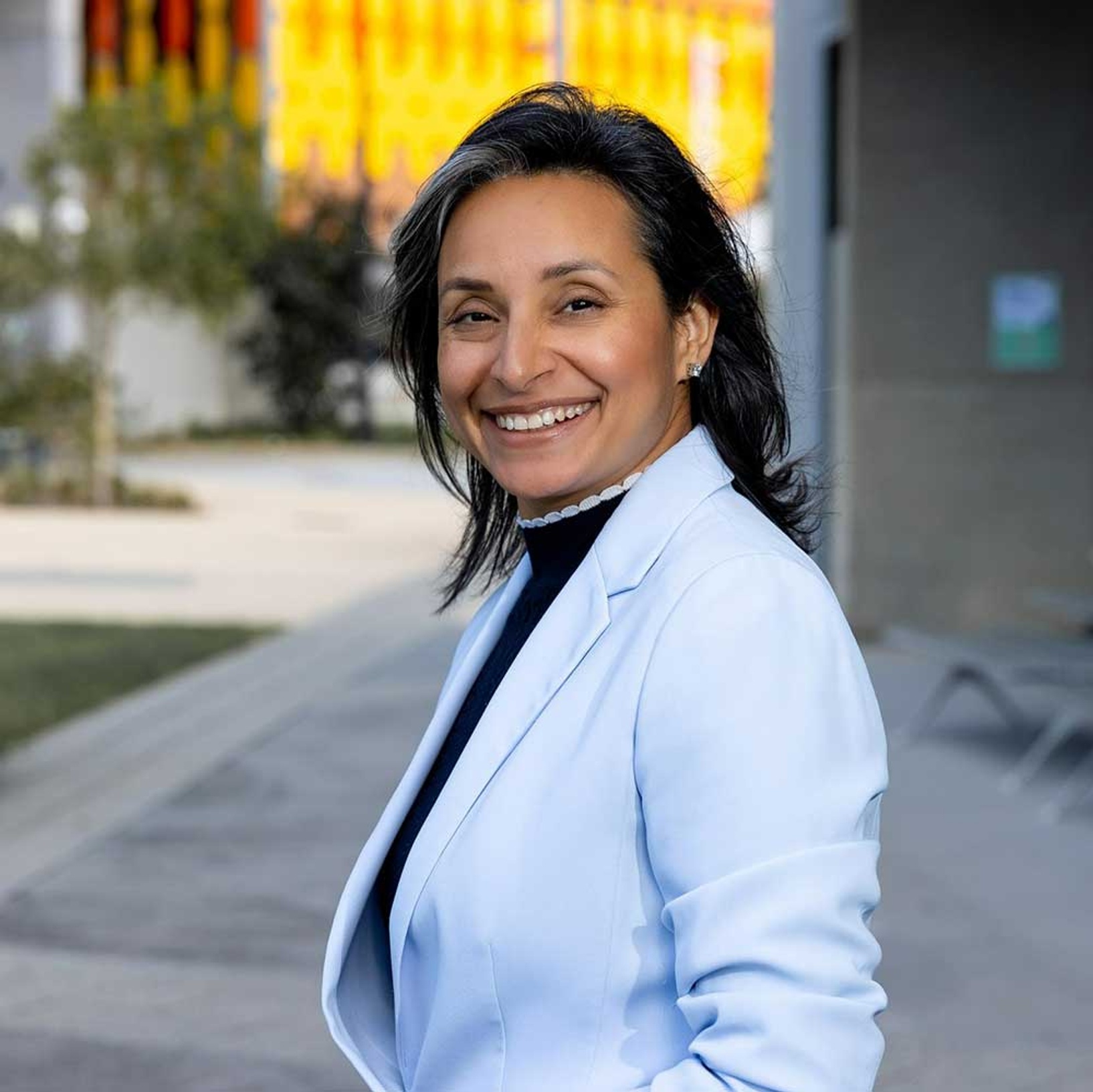 female wearing while coat smiling