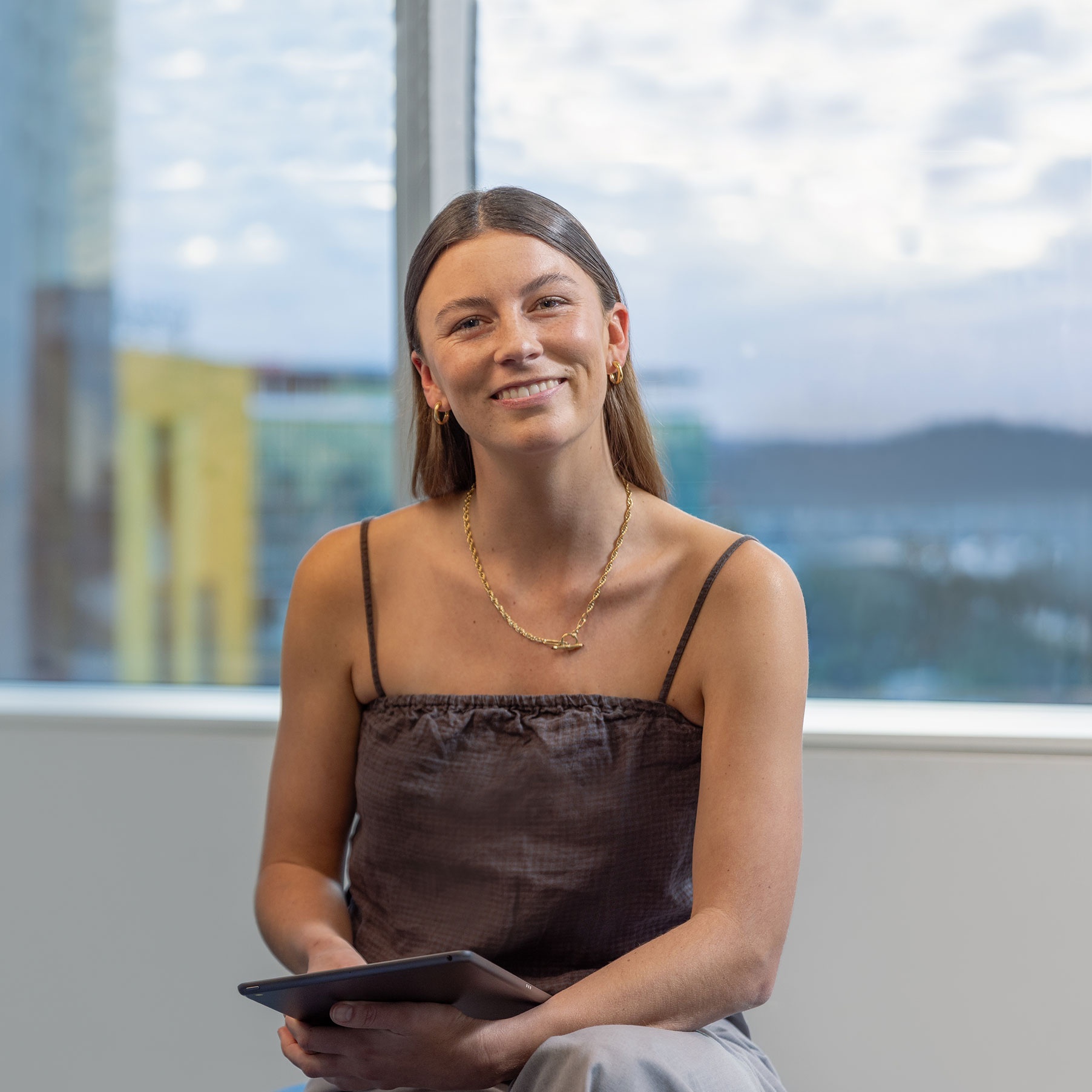 Girl sitting in front of window using tablet