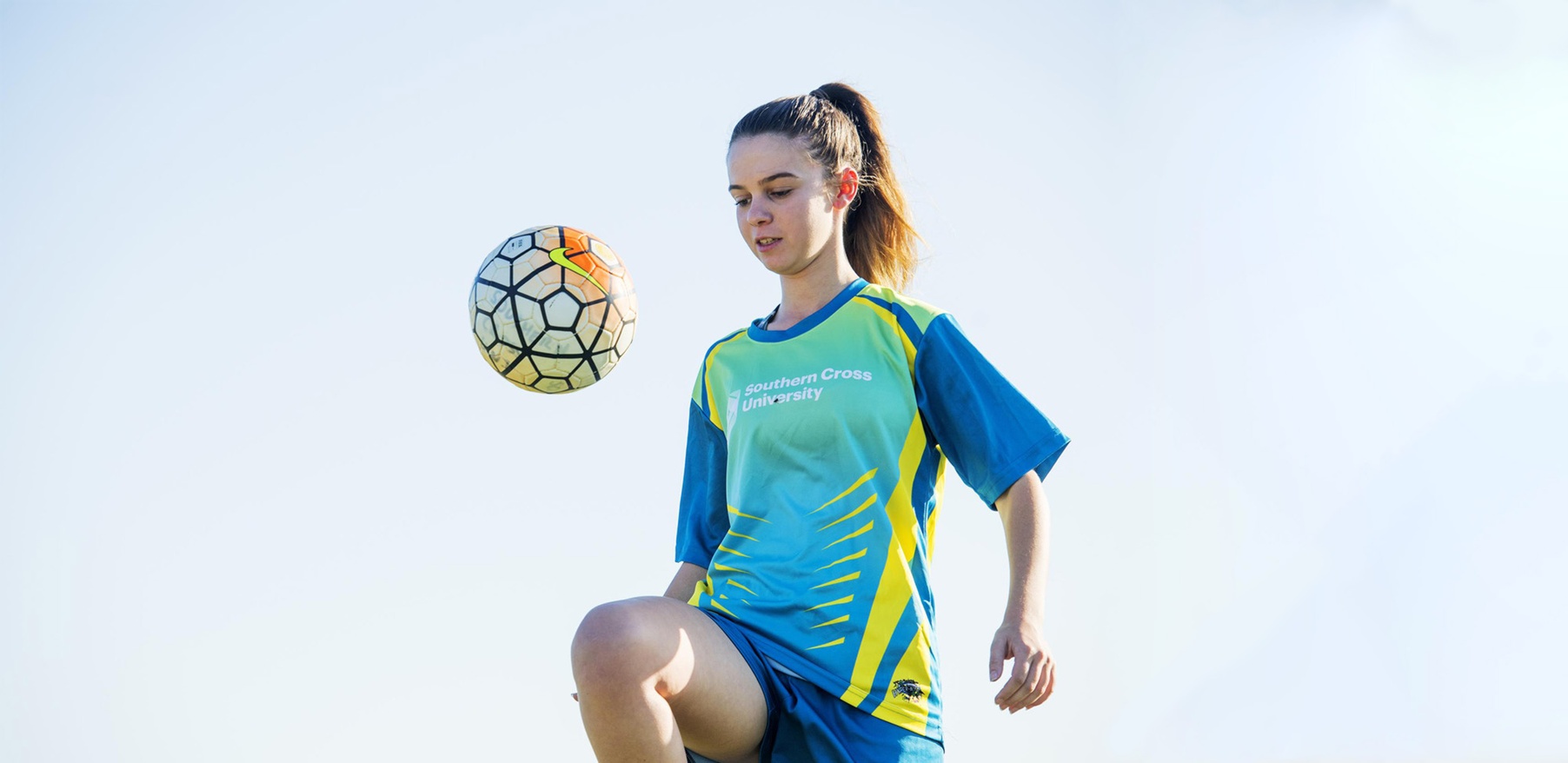 Portrait of Zoe Bertuzzi juggling soccer ball in Team SCU uniform