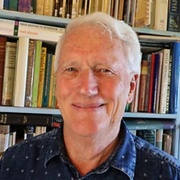 Smiling man with bookcase in background