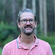A man in a forest looks at the camera