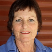 profile style photo of lady smiling at camera, wearing blue collared shirt