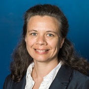 profile style photo of lady smiling at camera, wearing white dress shirt and dark jacket