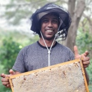 Portait pic of man holding a honey bee frame