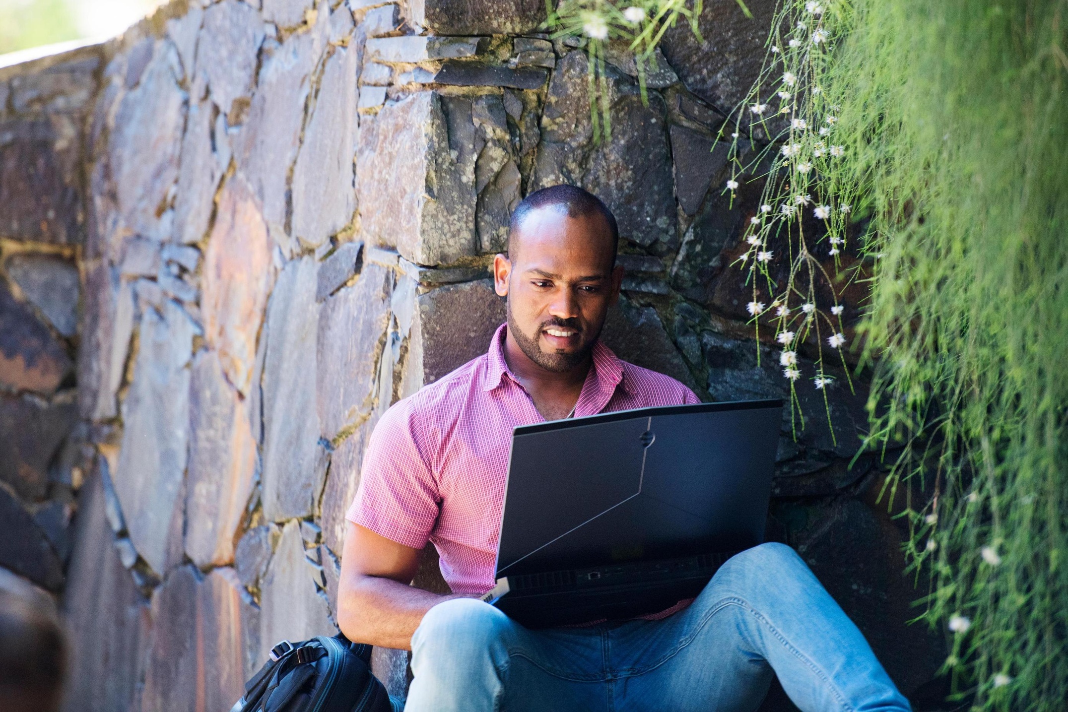 Student in garden with laptop