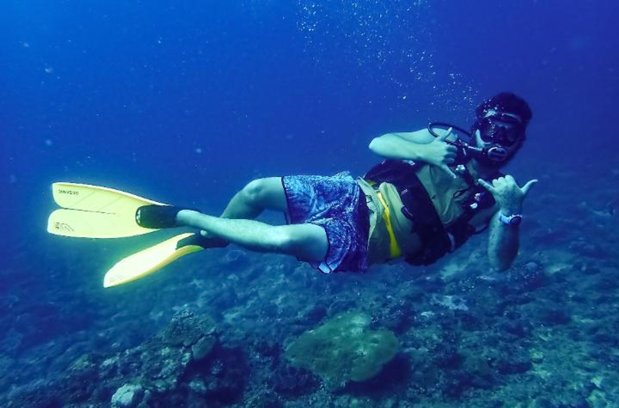 man diving underwater in scuba gear