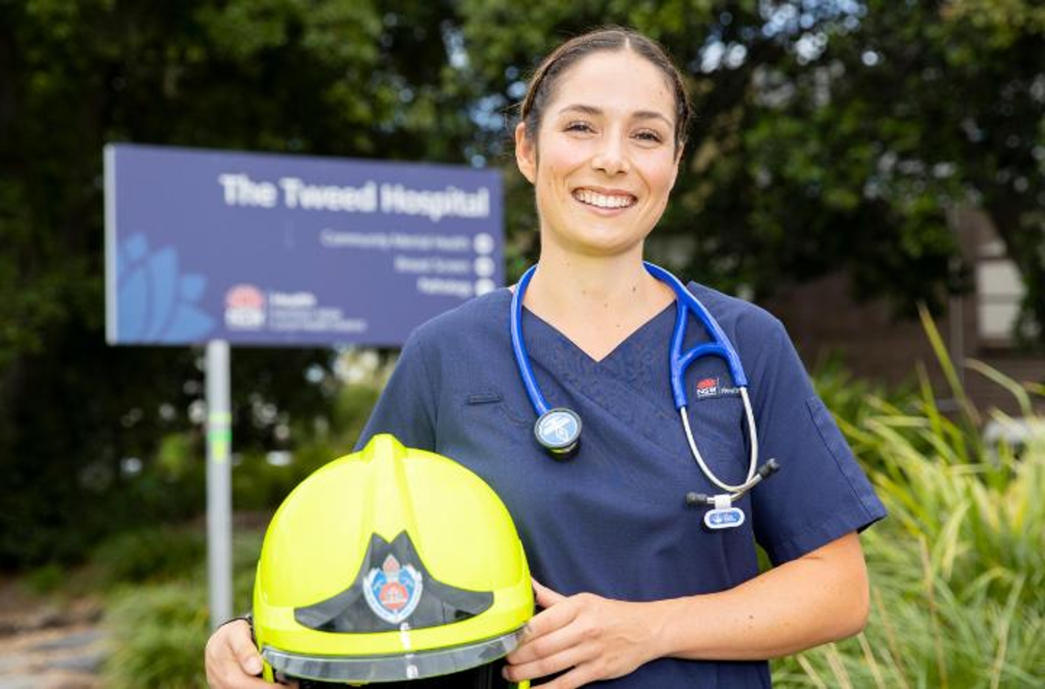 Bachelor of Nursing graduate Sophie Longworth at the front of the Tweed Hospital holding fire fighter helmet