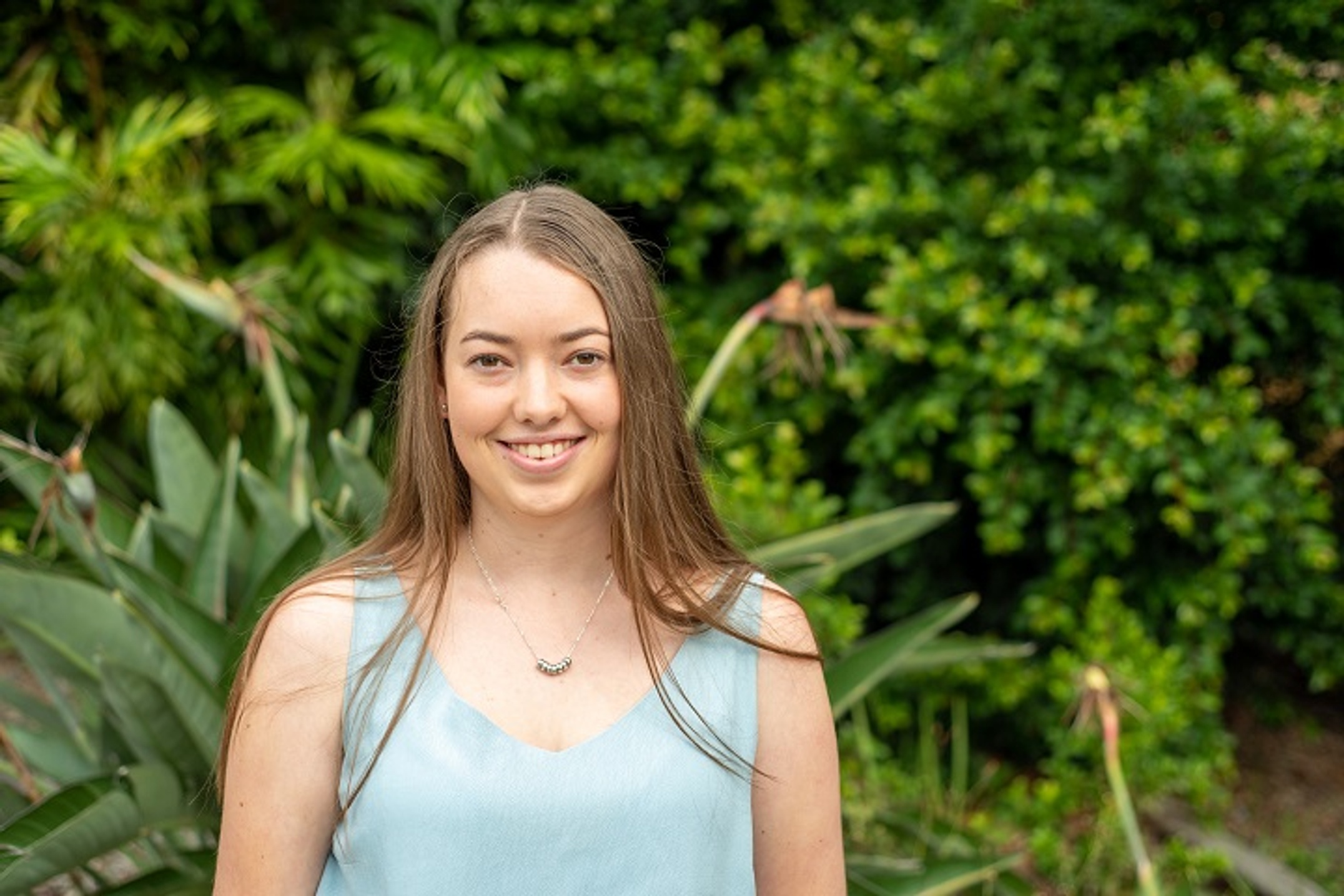 Female student smiling against green backdrop