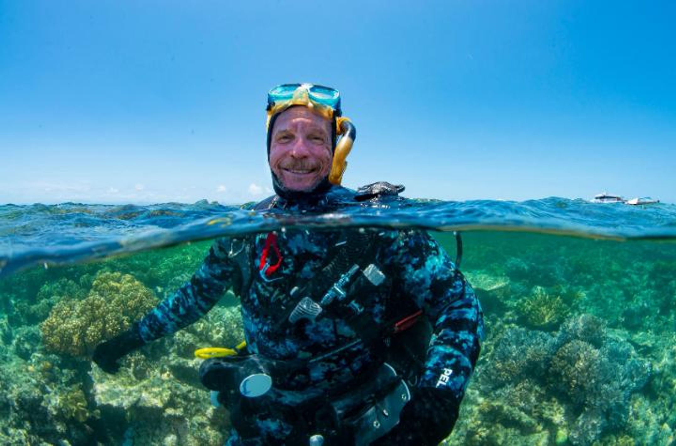 Scuba diver emerging from the ocean surrounded by coral reef