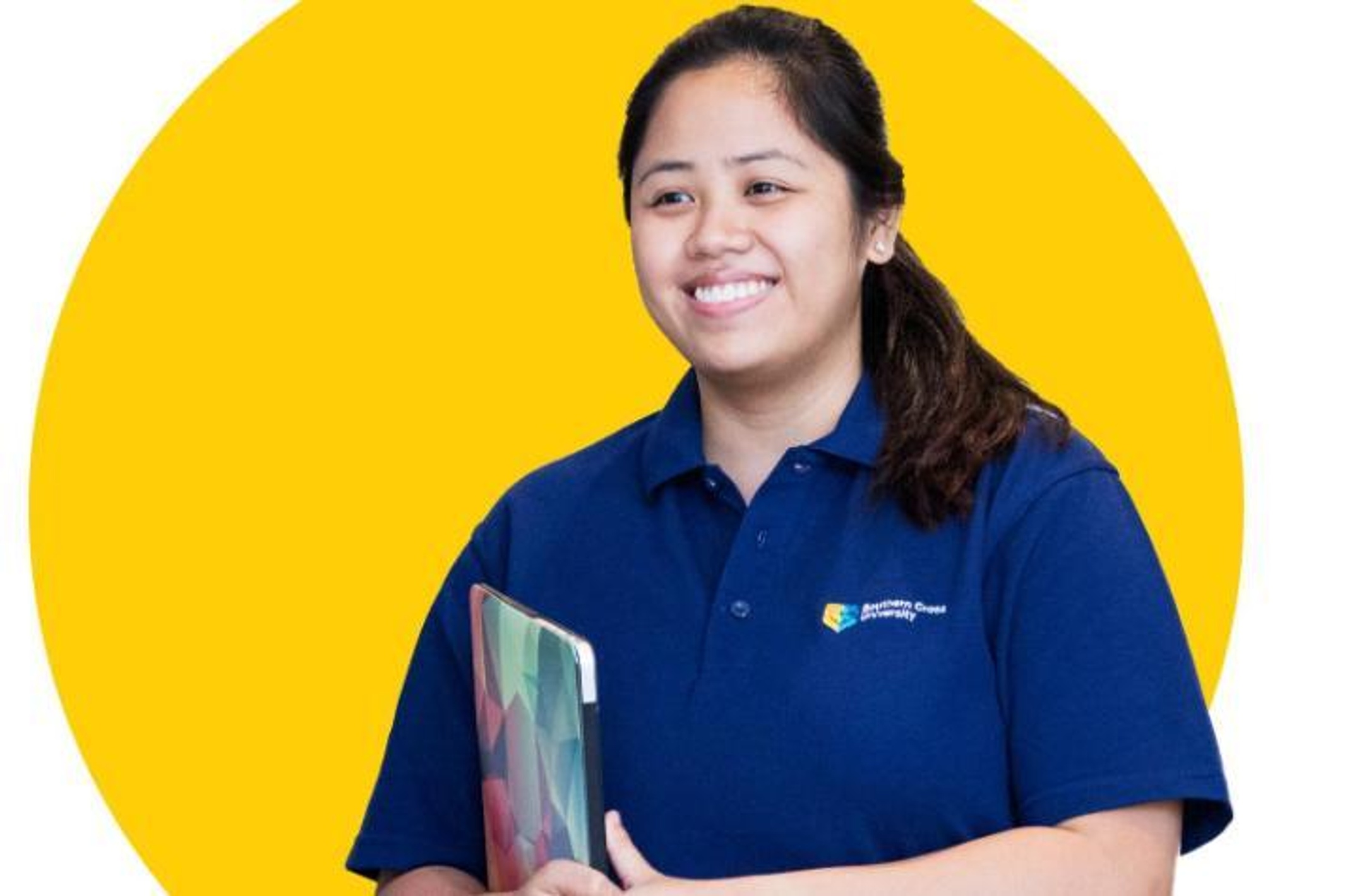 Female student with long dark hair wearing SCU polo shirt and holding laptop