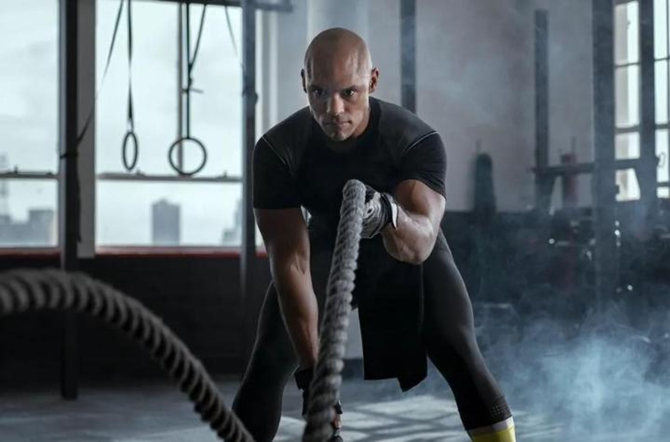 Man swinging ropes in the gym