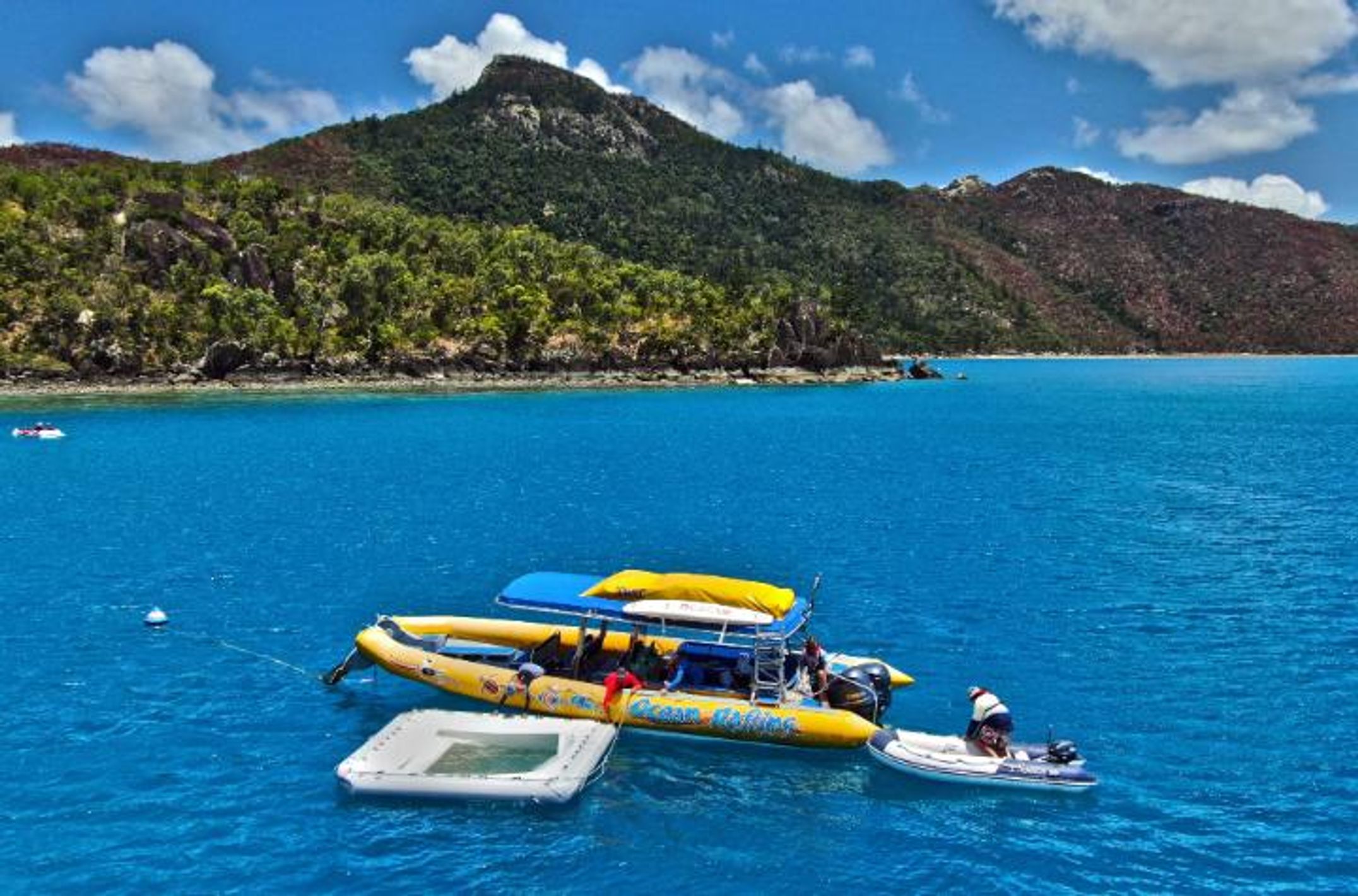 Boat in the ocean towing a coral larvae nursery pool