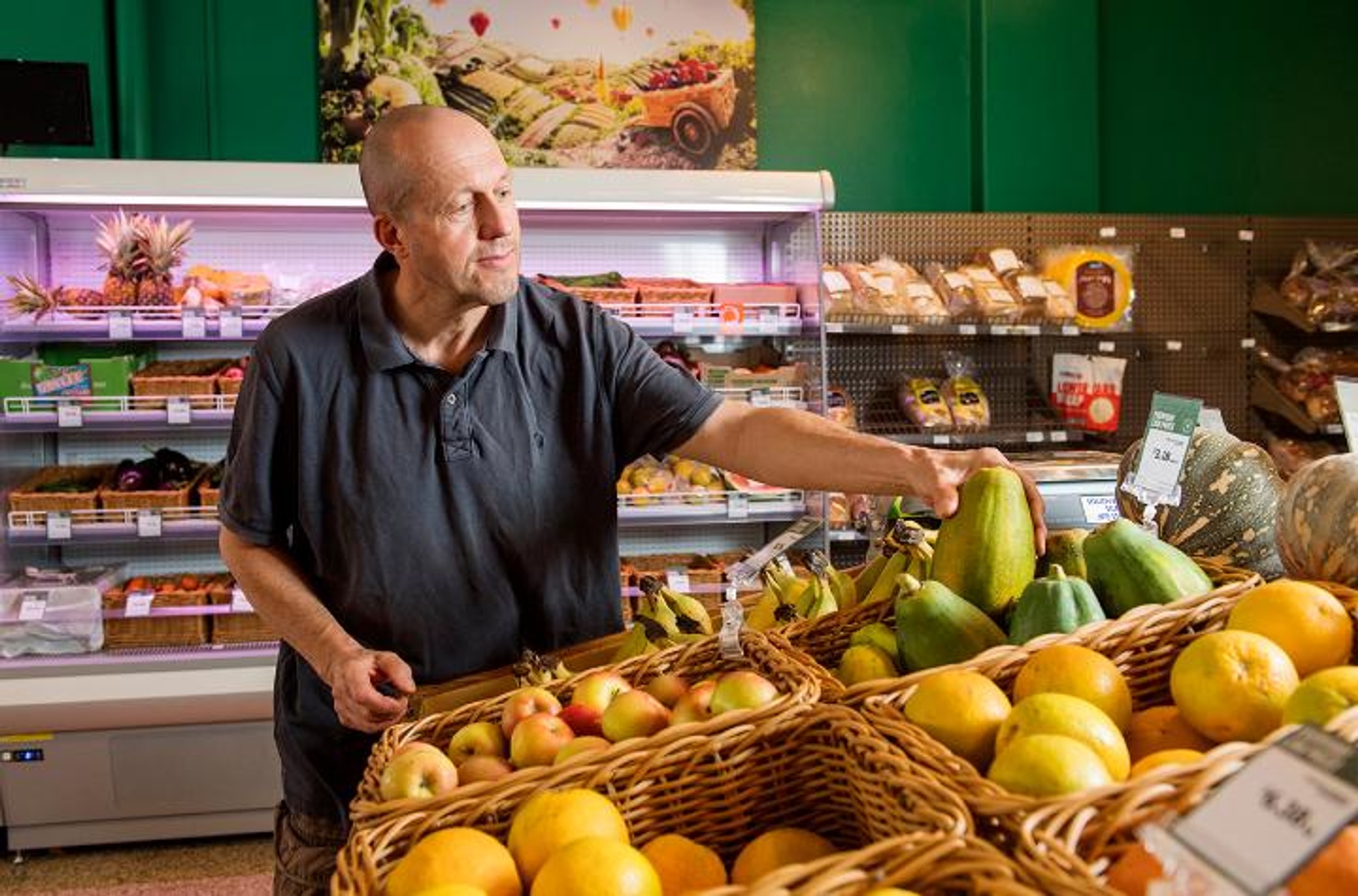 A man inspecting fruit at a supermarket