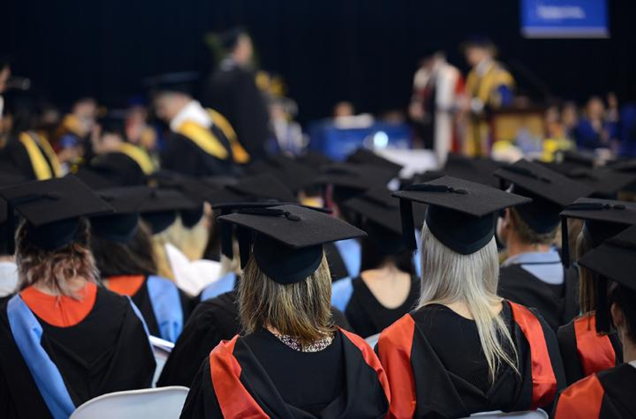 Students at a graduation ceremony wearing ceremonial gowns and motar boards