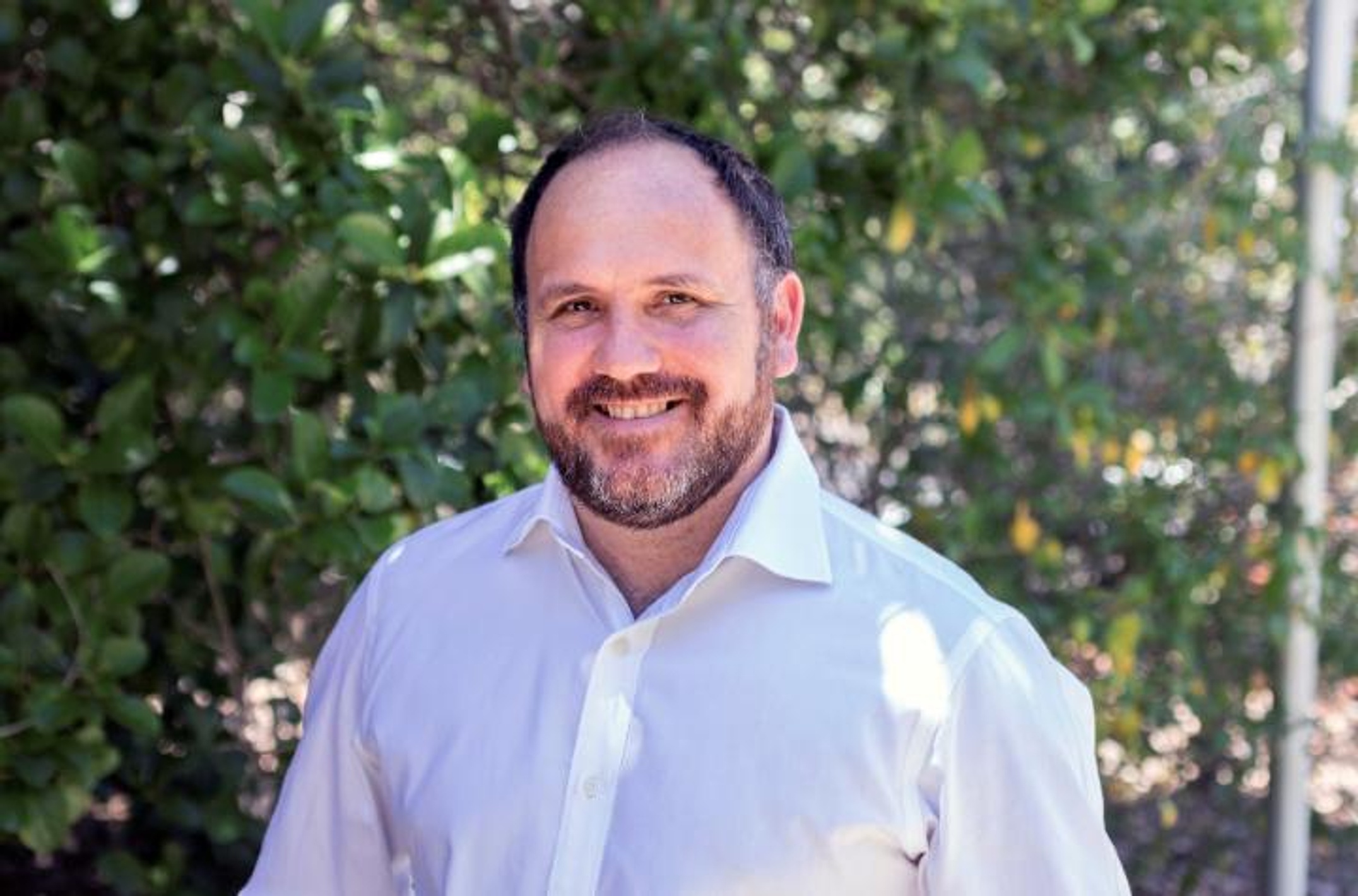 A man with a beard wearing a white shirt