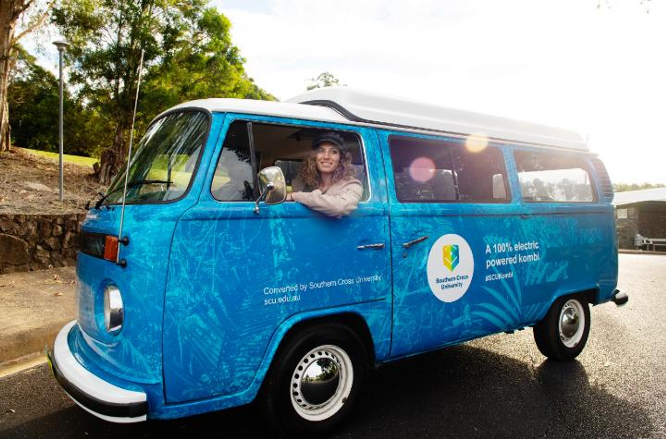 Kombi van in Southern Cross University colours with two people inside