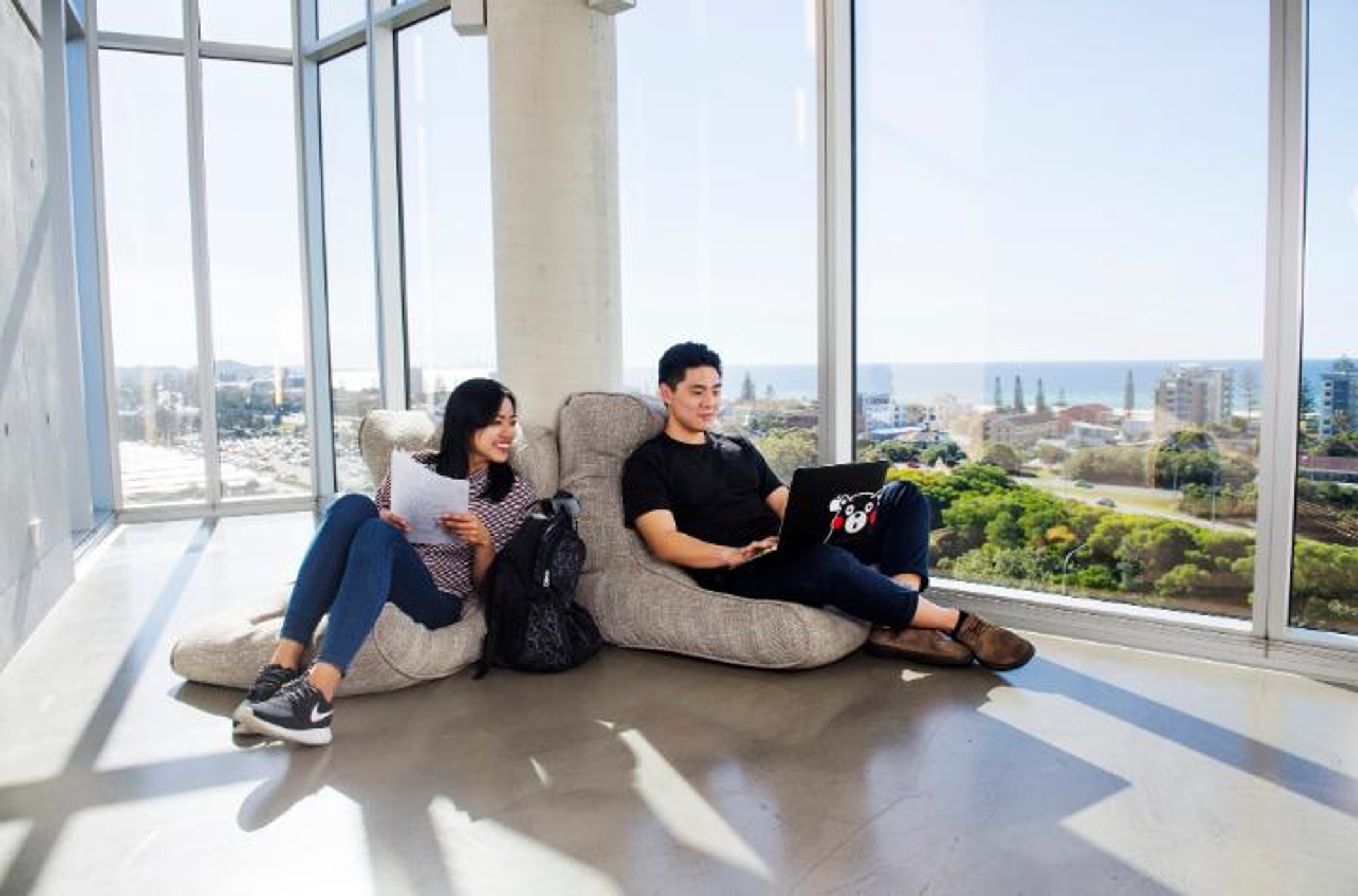 Two students with laptops at the Gold Coast campus