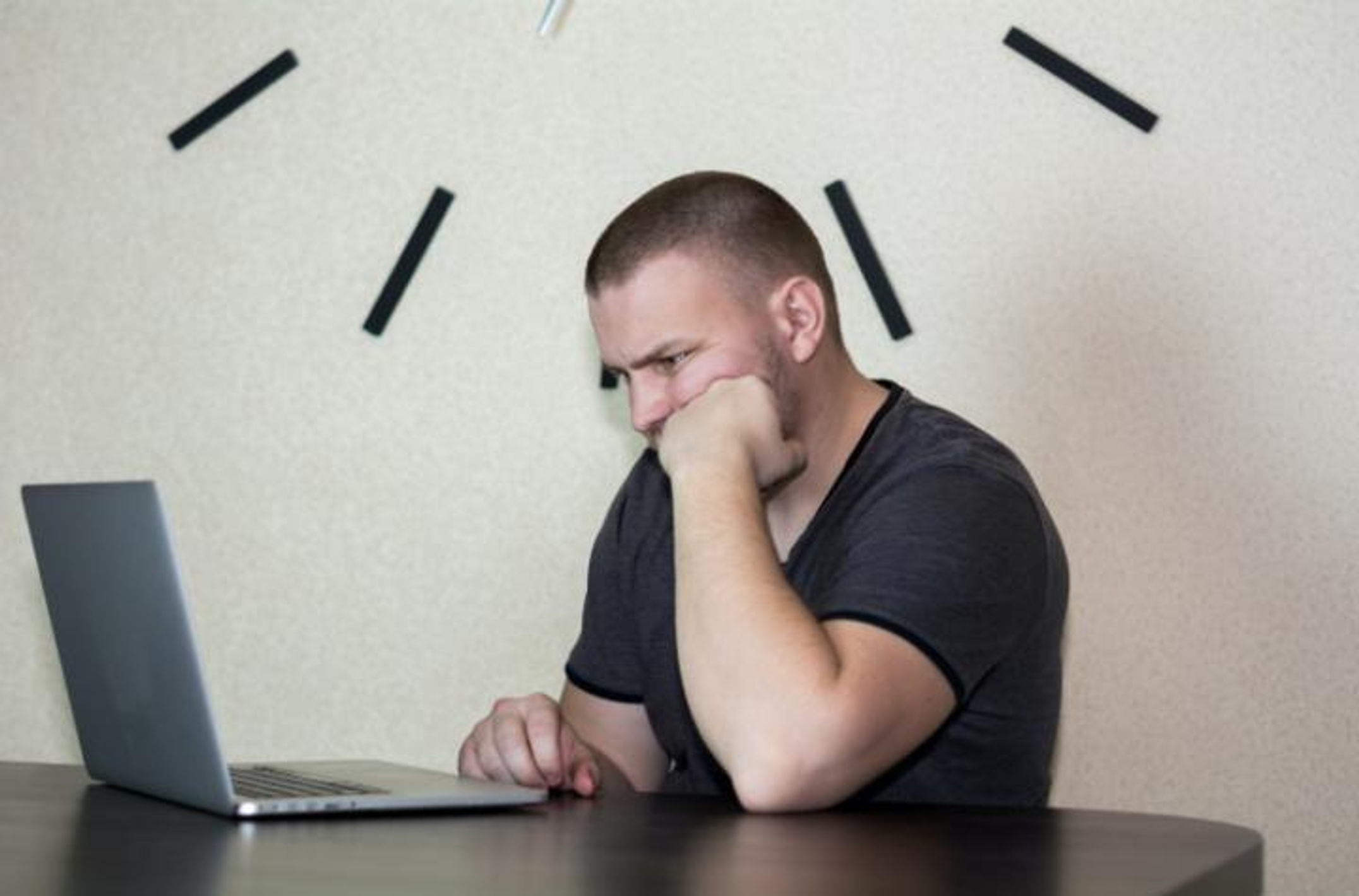 Man looking upset in front of a laptop