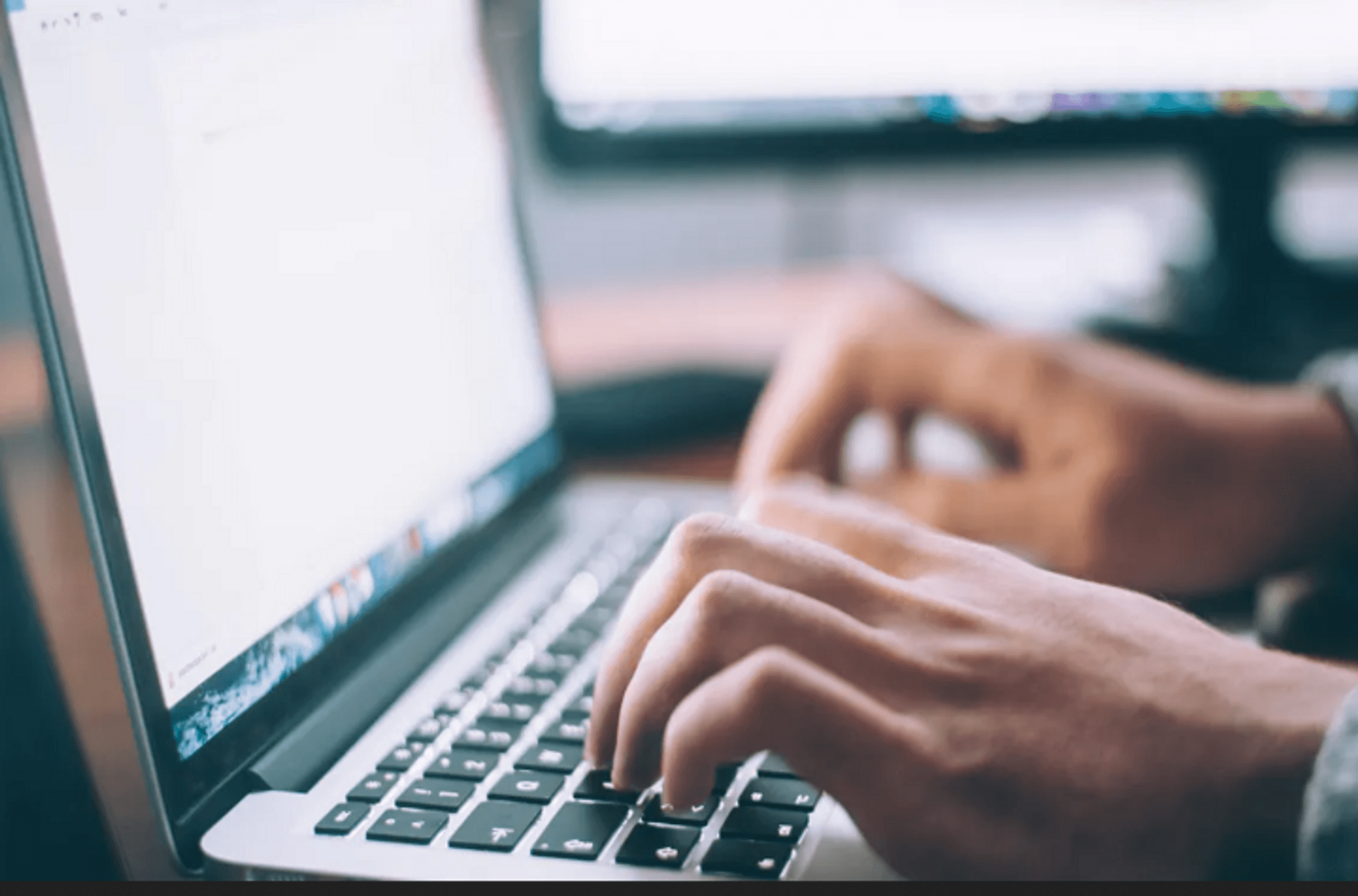 Person's hands using keyboard of a laptop