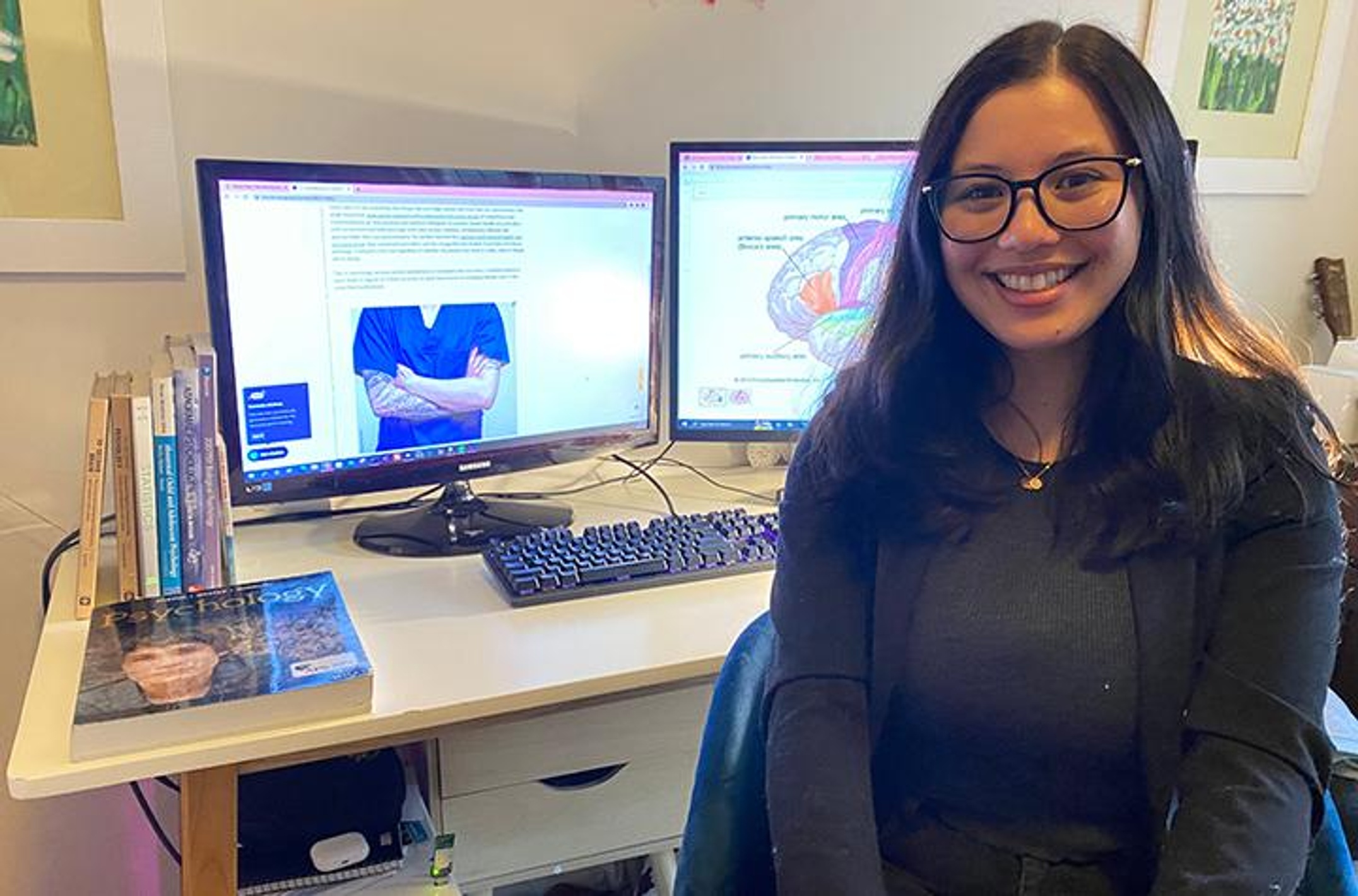A woman sitting in front of her computer and textbooks