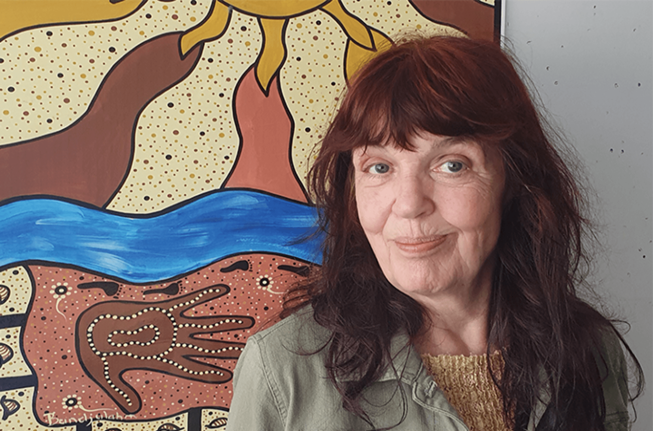 Dr Liz Rix in front of Indigenous artwork