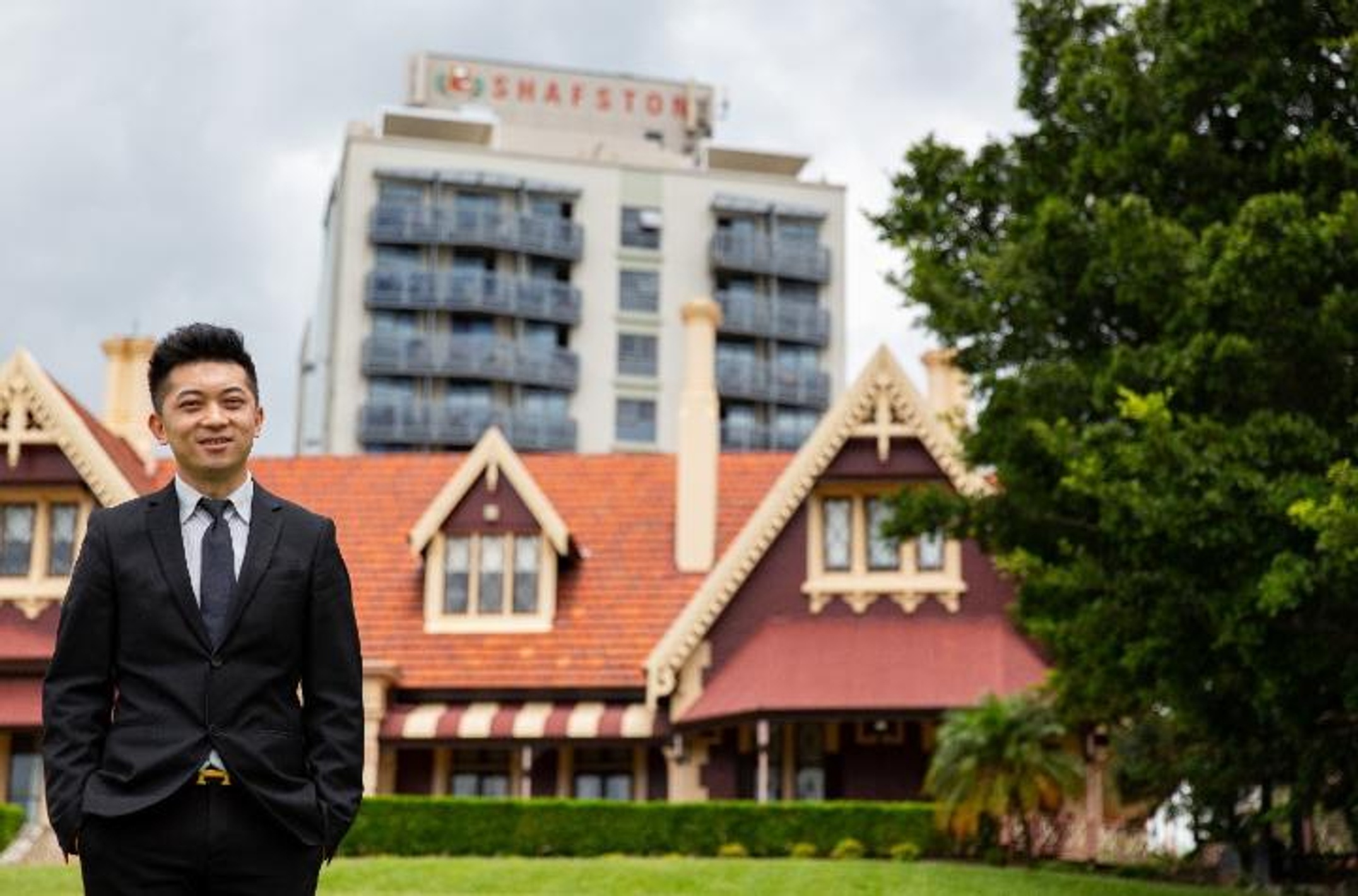 A man stands in front of a historic building