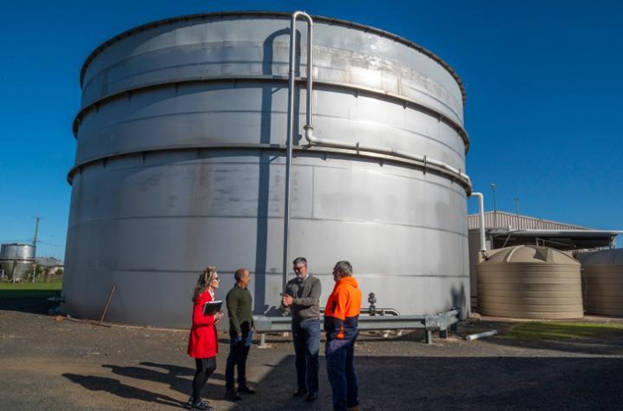 A group of people in front of a large silo
