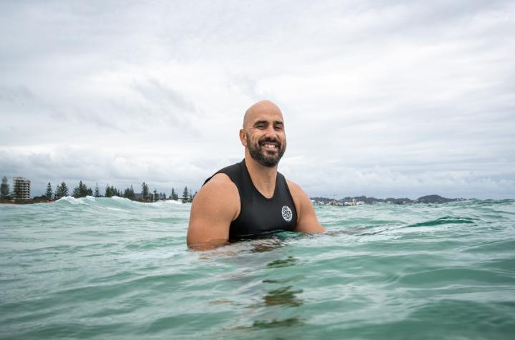 Man on a surfboard smiling at the camera