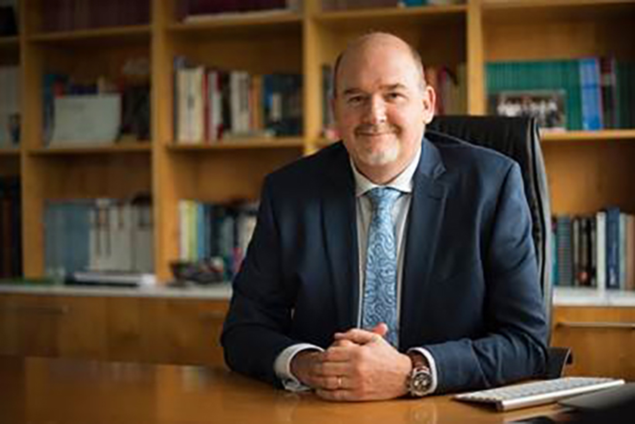 A man in a suit and tie sitting at a desk