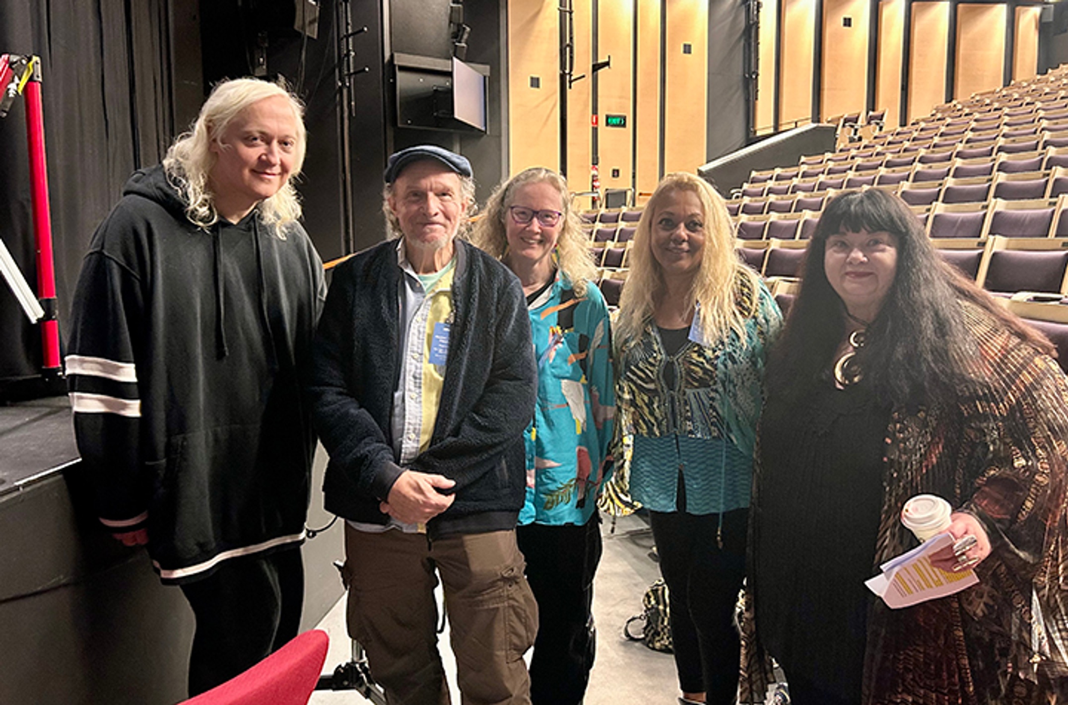 A group of people off-stage at a concert hall.