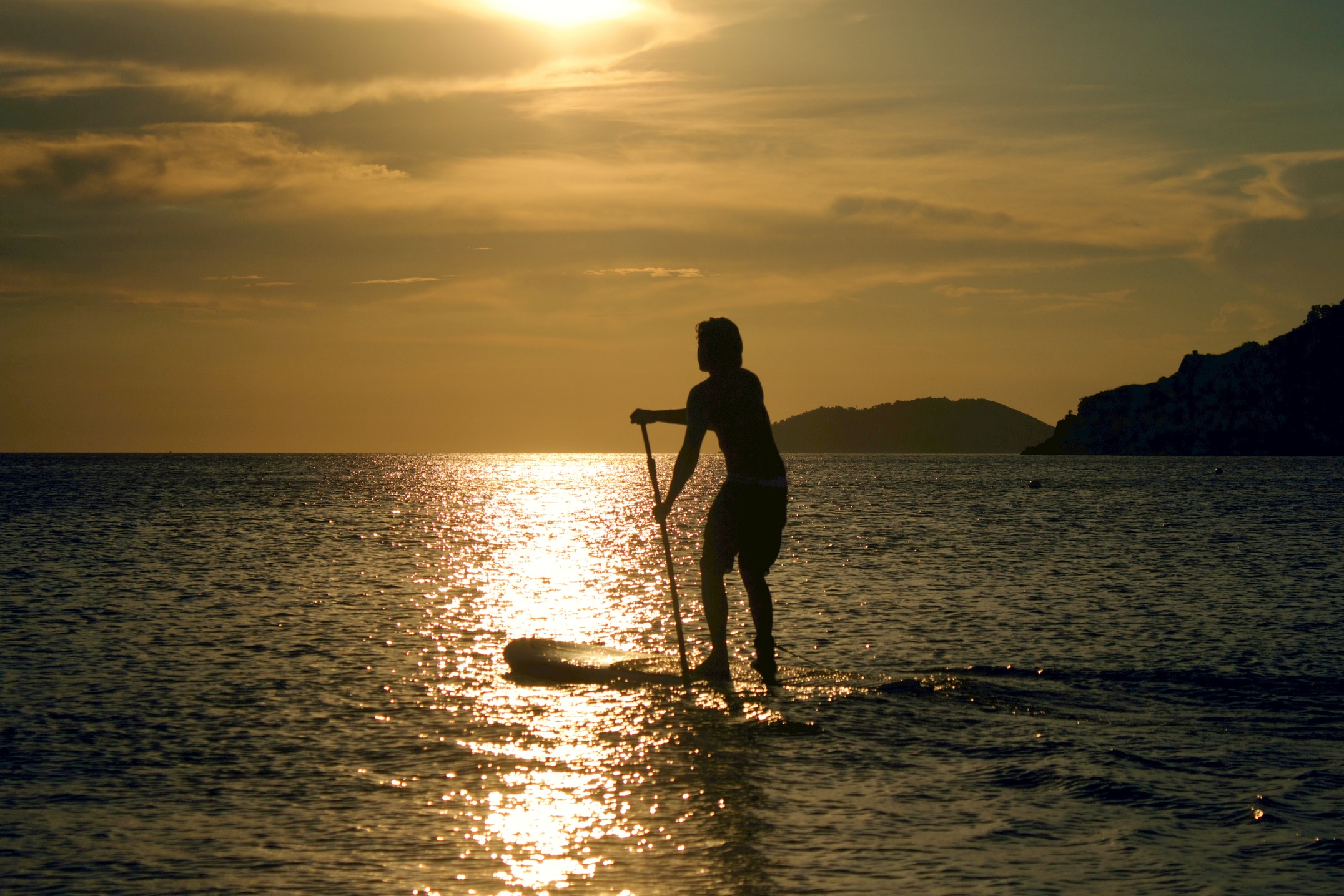 SUP stand up paddleboarder in the sun credit Eduardo Taulois on Unsplash
