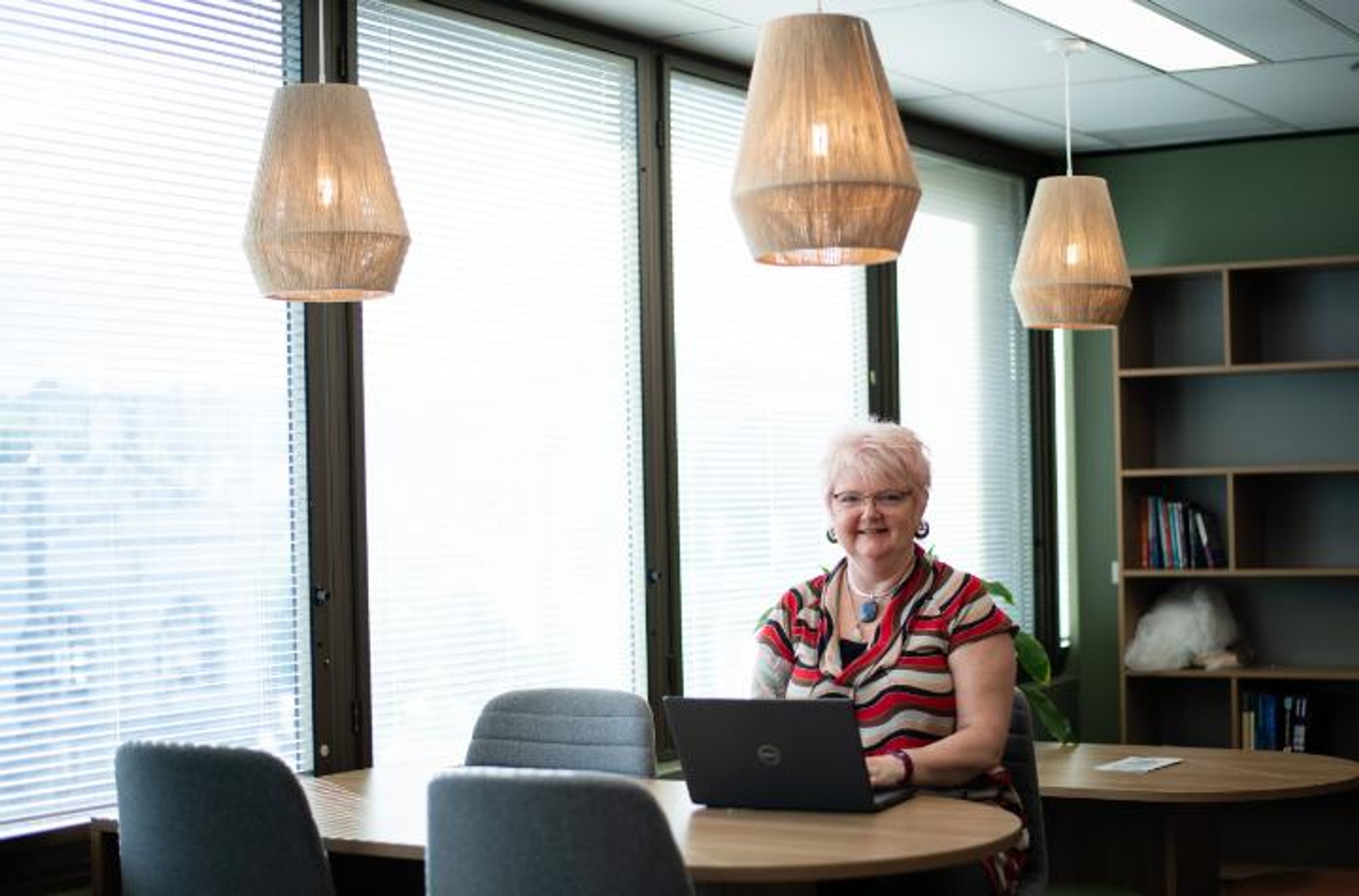 A woman sitting at a table with a laptop