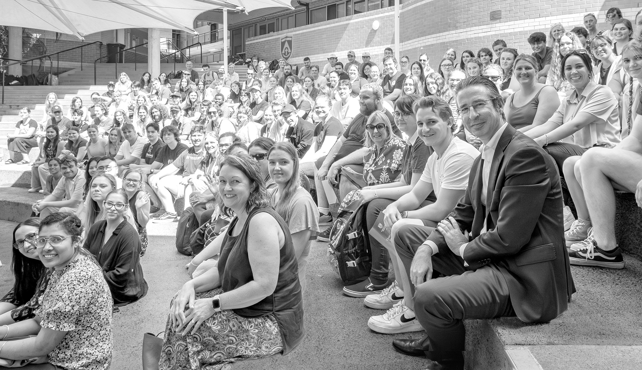 Group of people on tiered seating looking at camera