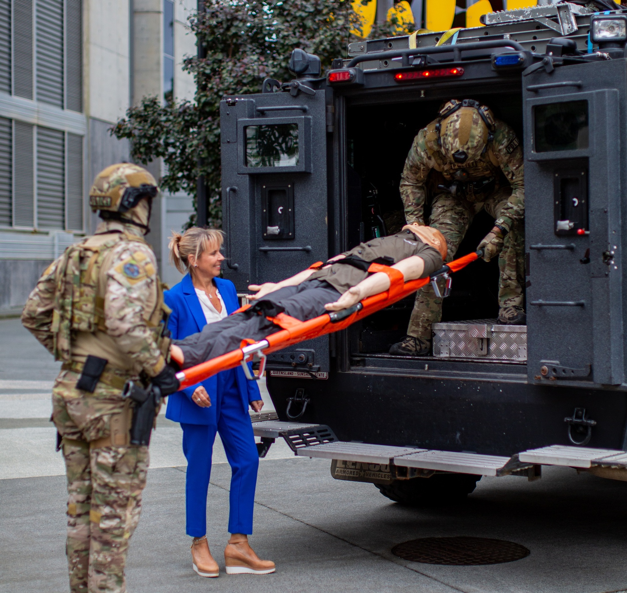 Two police officers load a a mannikin onto a special response vehicle