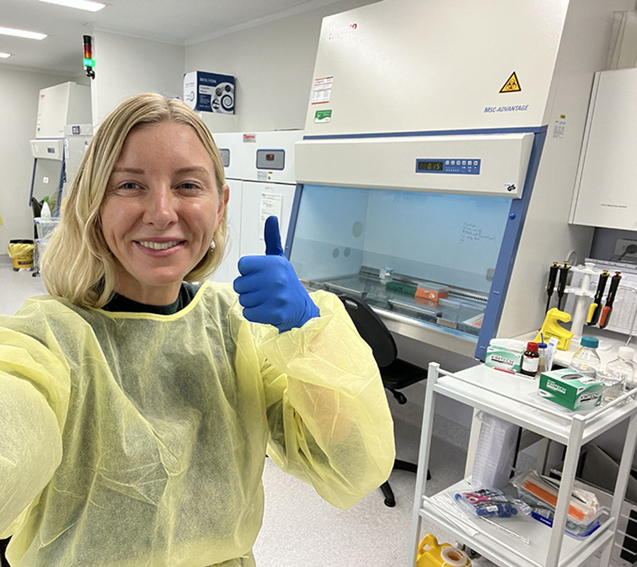 A woman wearing yellow protective clothing in the laboratory.