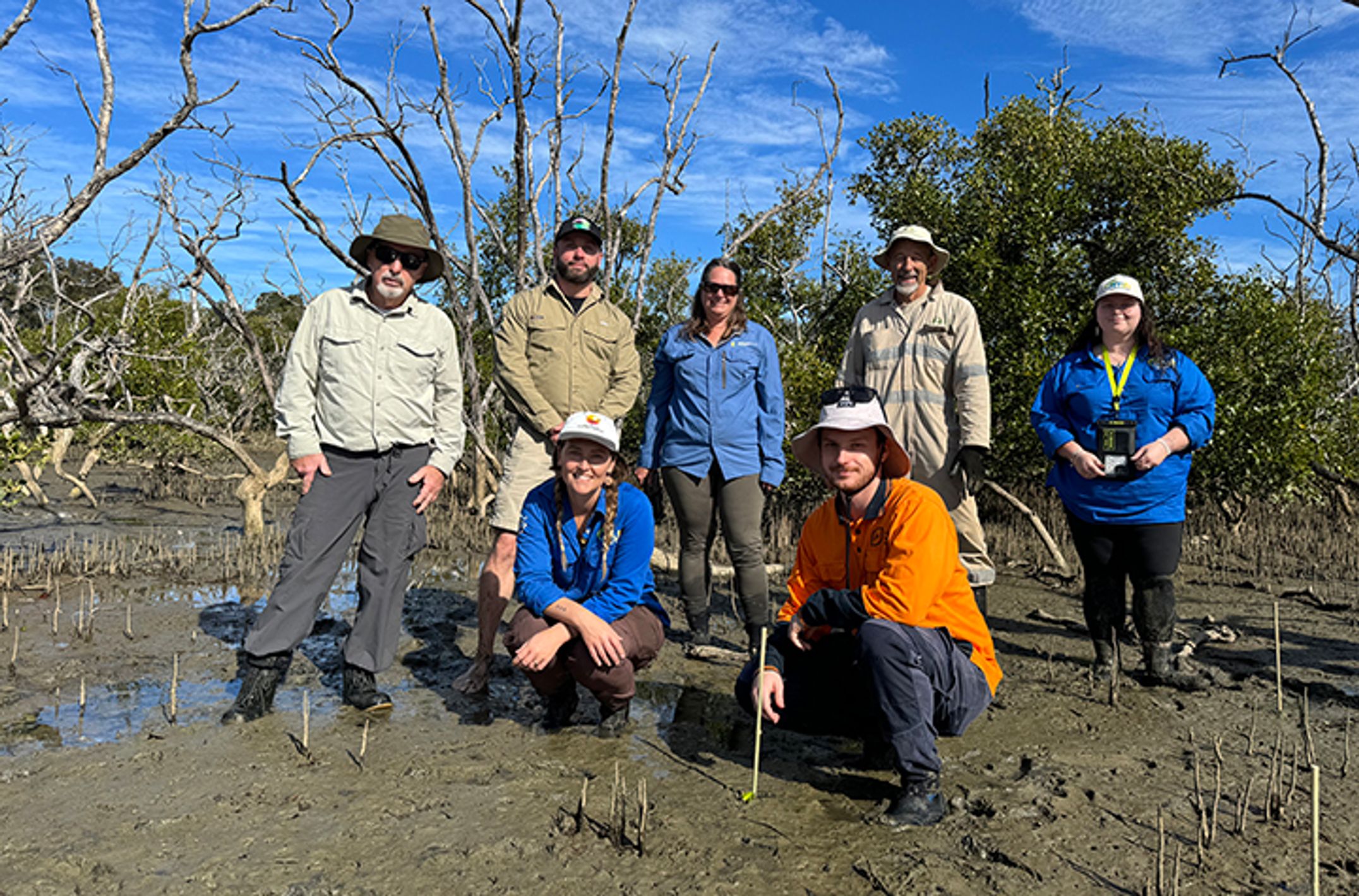 A group of people standing in an estuary