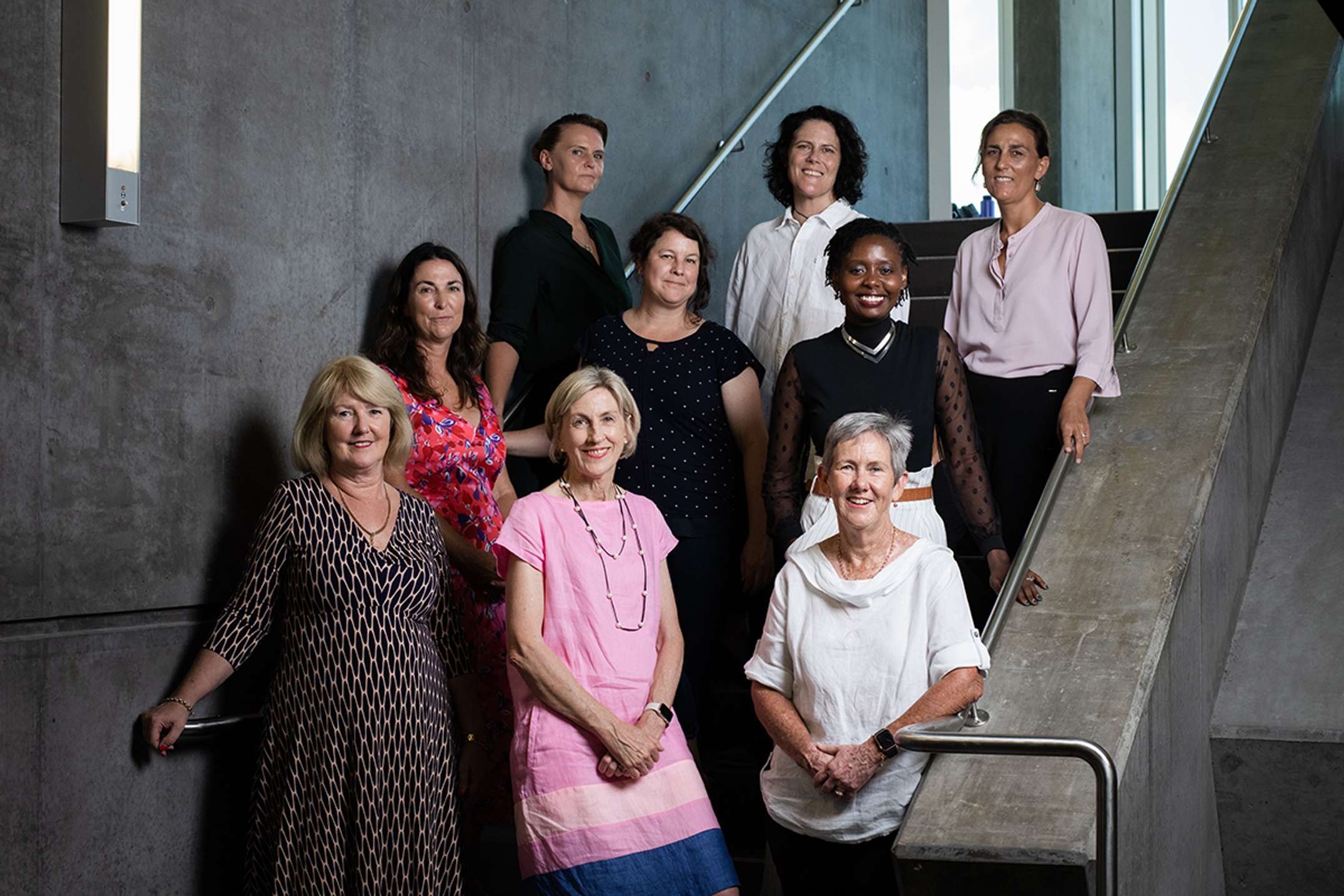 Group of people arranged on a staircase looking at the camera