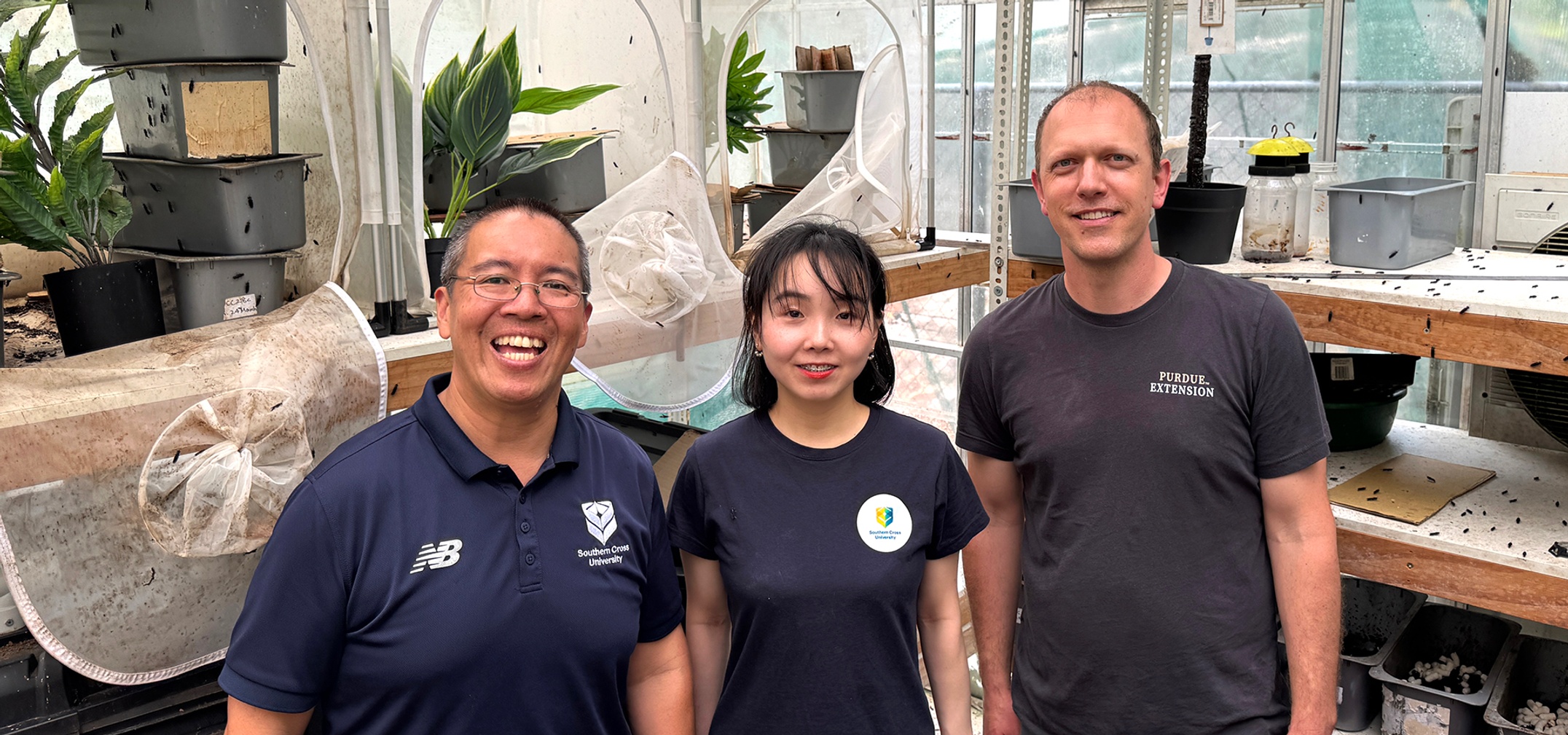 Three people in a greenhouse setting
